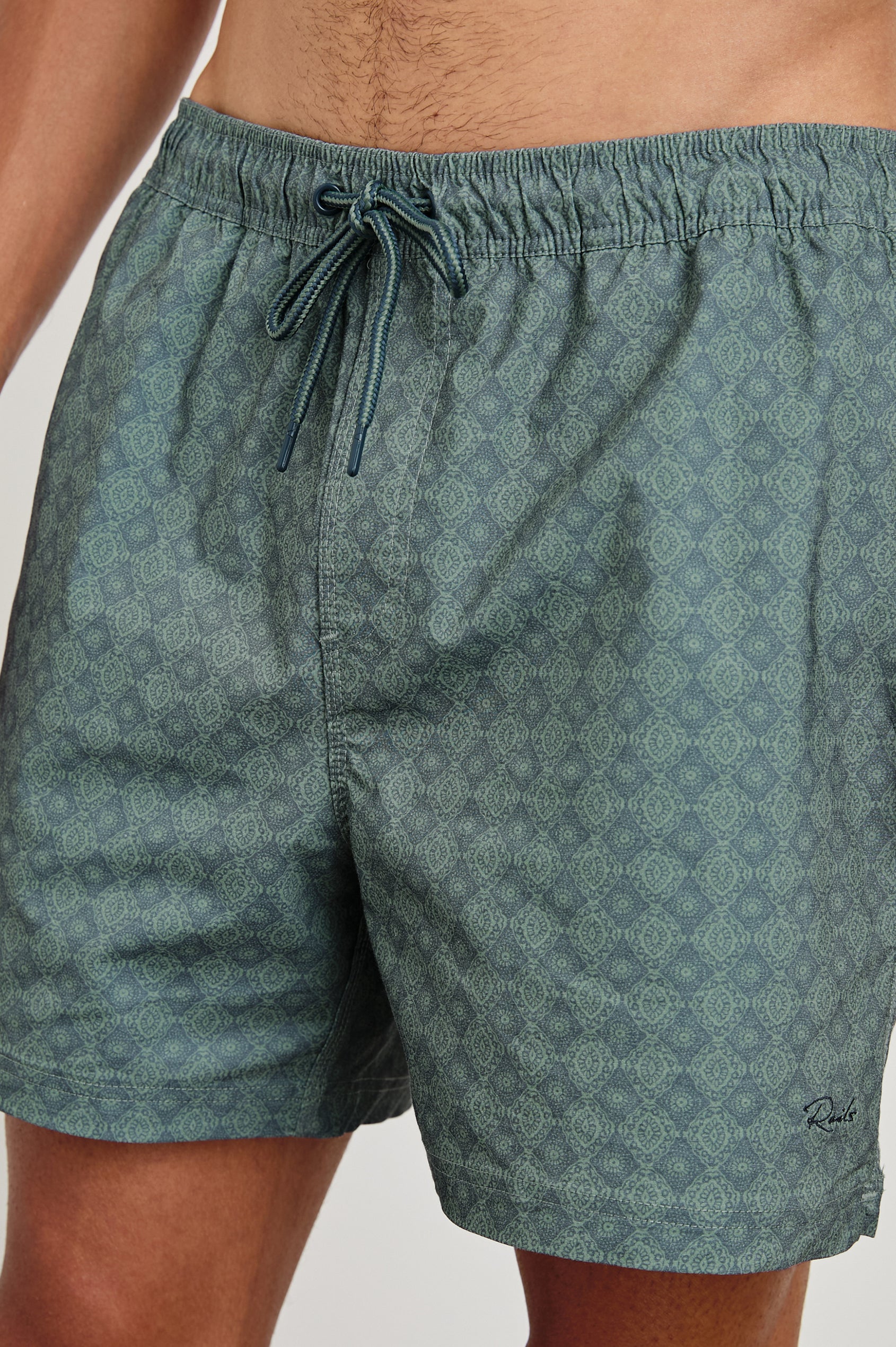 La Brea mid-length swim short with adjustable waist drawstring with ornamental pattern in Diamon Thunder Grass - close up of details on model