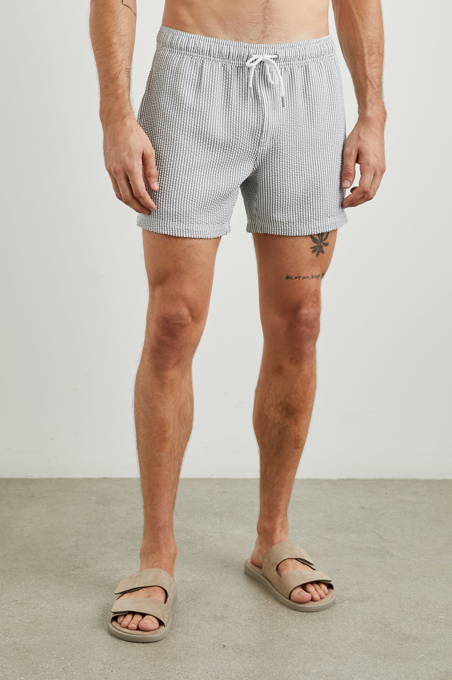 La Brea Swim Shorts with a Drawstring Waist, Two Front Pockets and a Back Patch Pocket in Faded Seersucker Colorway,  Grey and white thin vertical stripes - Front View Featured on Model