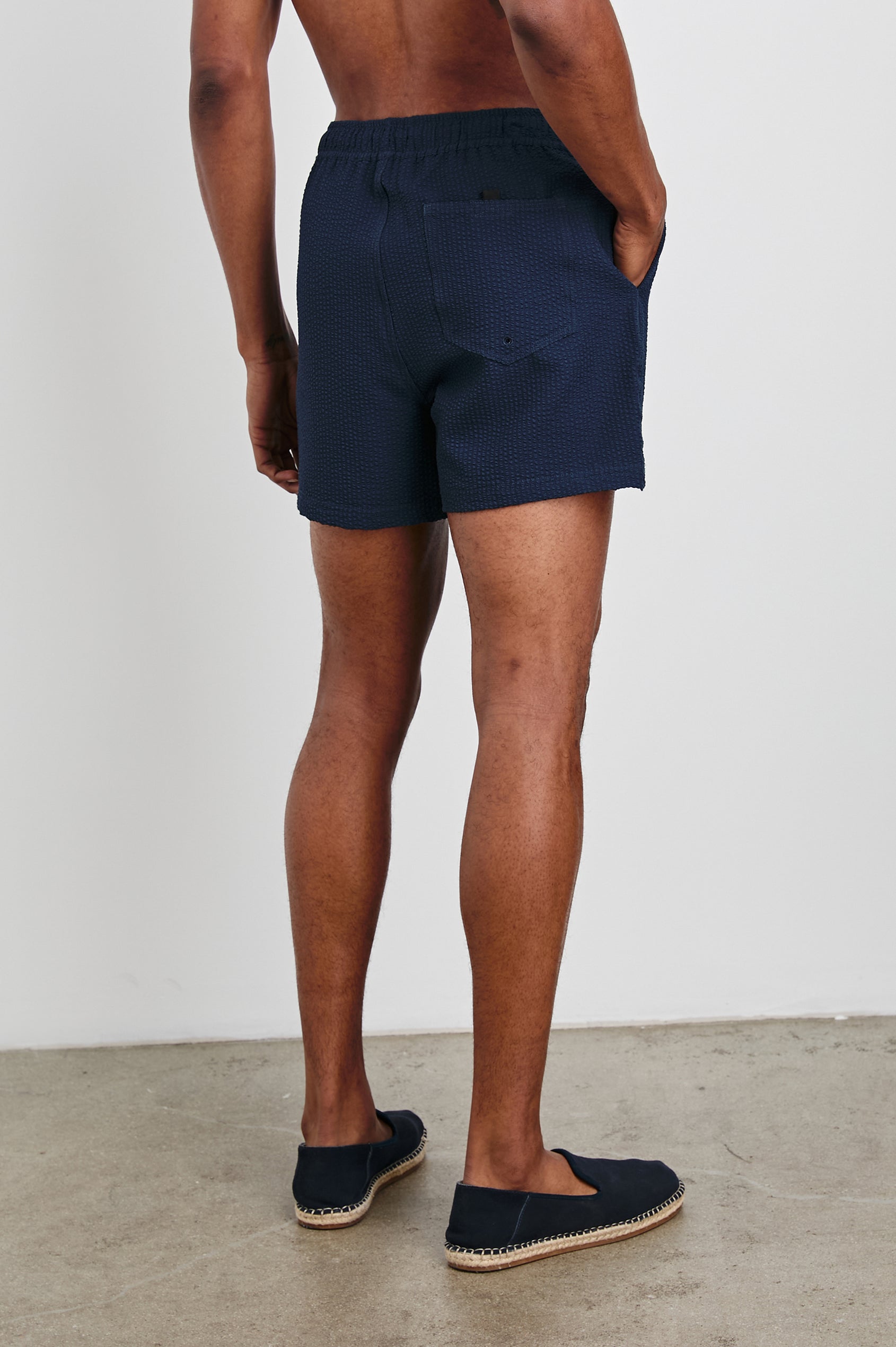 La Brea textured mid-length swim short with adjustable waist drawstring in Navy Seersucker - back view on model