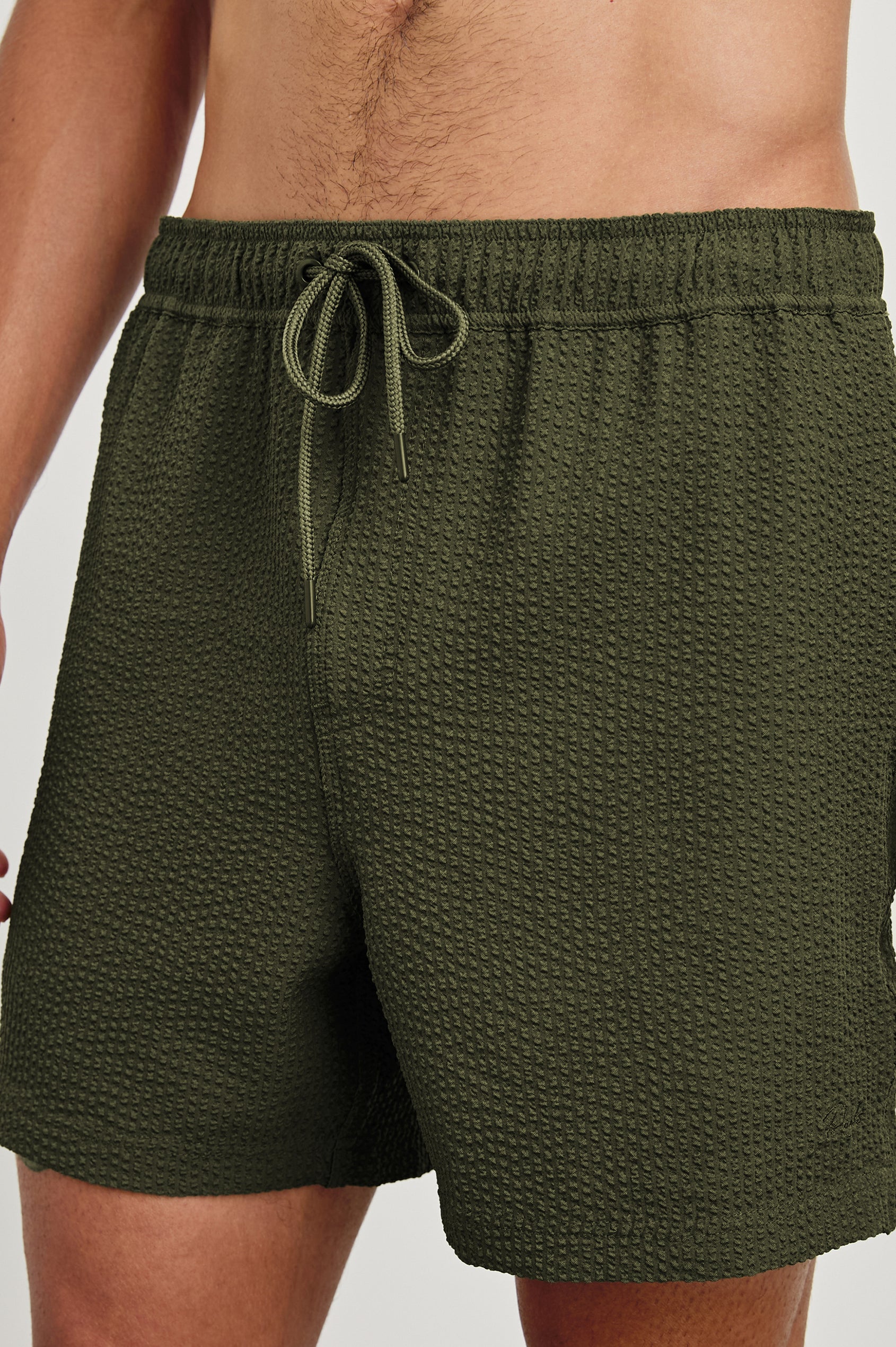 La Brea textured mid-length swim short with adjustable waist drawstring in Olive Seersucker - close up of details on model