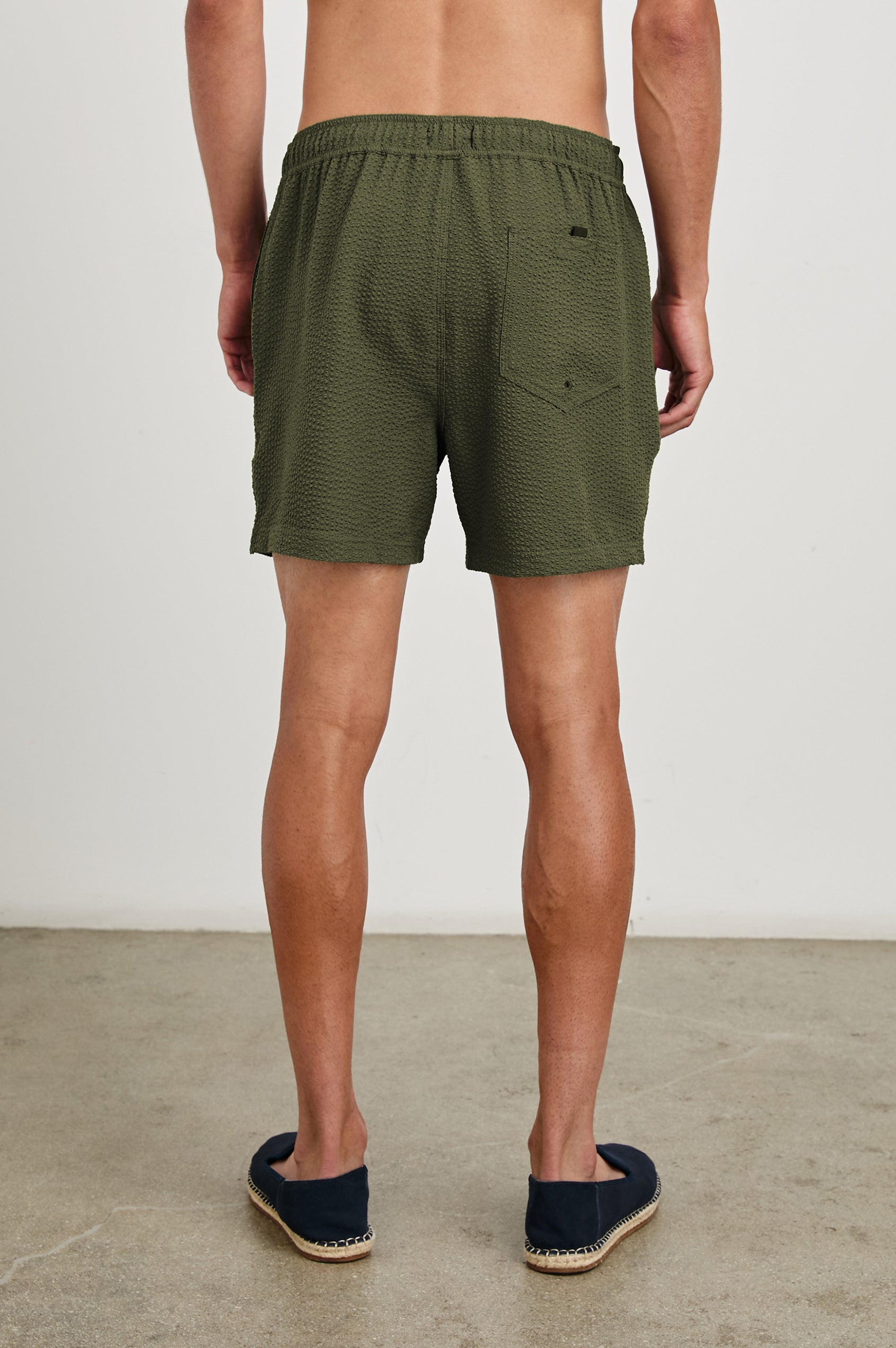 La Brea textured mid-length swim short with adjustable waist drawstring in Olive Seersucker - back view on model