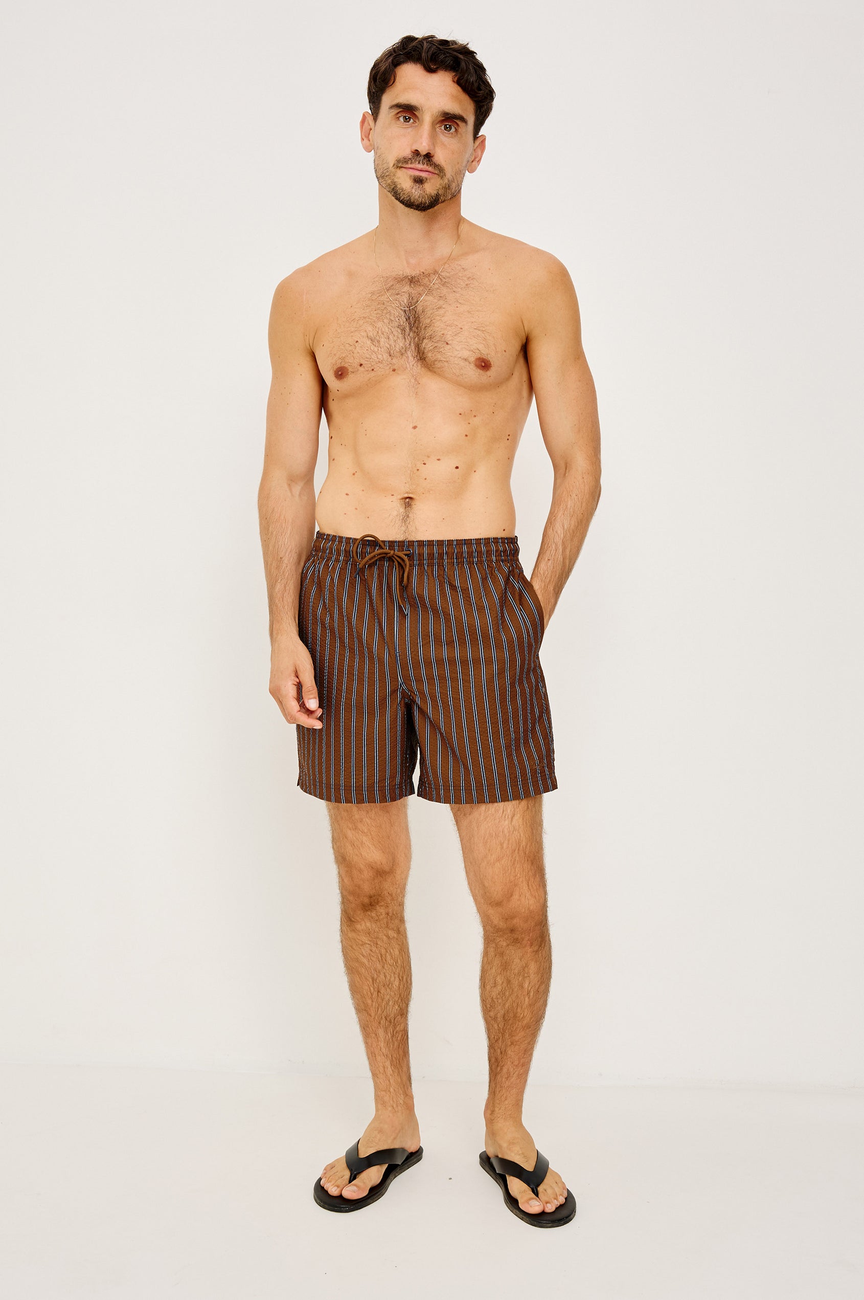 La Brea Mid-Length Swim Shorts With Adjustable Waist Drawstring Ties and Side Pockets in Rust Navy Stripe Colorway - Full Body Front View Featured on Model