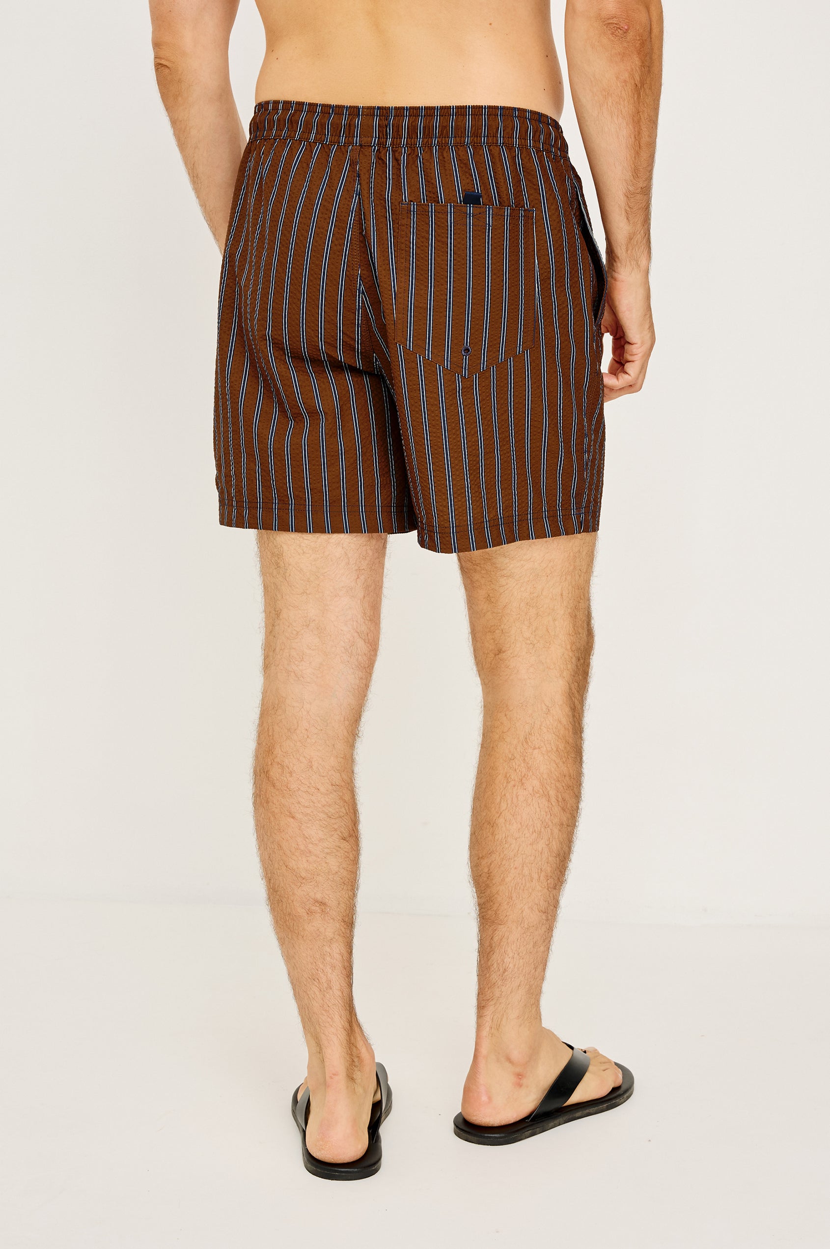 La Brea Mid-Length Swim Shorts With Adjustable Waist Drawstring Ties and Side Pockets in Rust Navy Stripe Colorway - Lower Body Back View Featured on Model