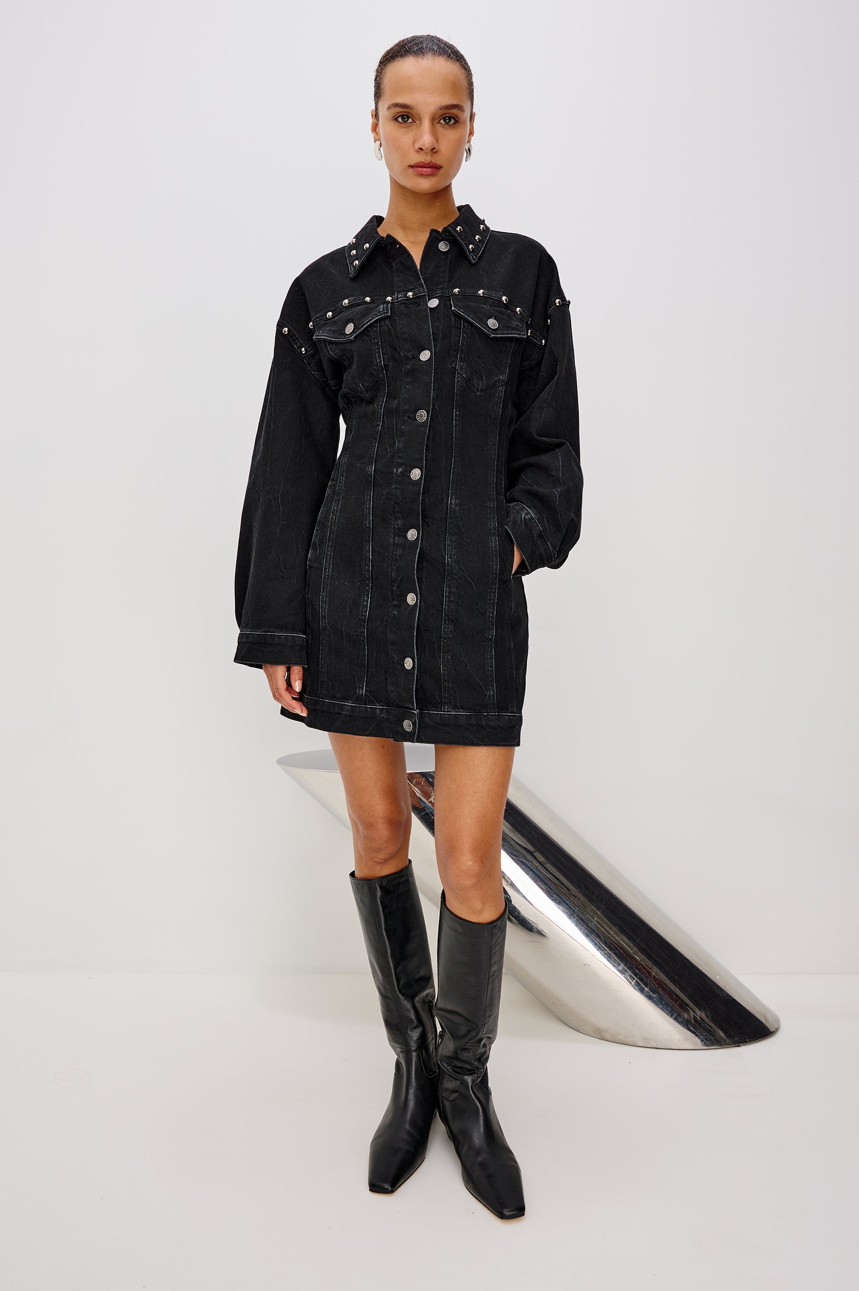 Ladera Mini Dress in Denim With Subtle Stretch, Drop Shoulders, Collar, Relaxed Long Balloon Sleeves, Nail-Back Studs, Front Buttons, A-Line Shape, and Adjustable Back Strap in Black Stone Studded Colorway - Full Body Front View Featured on Model