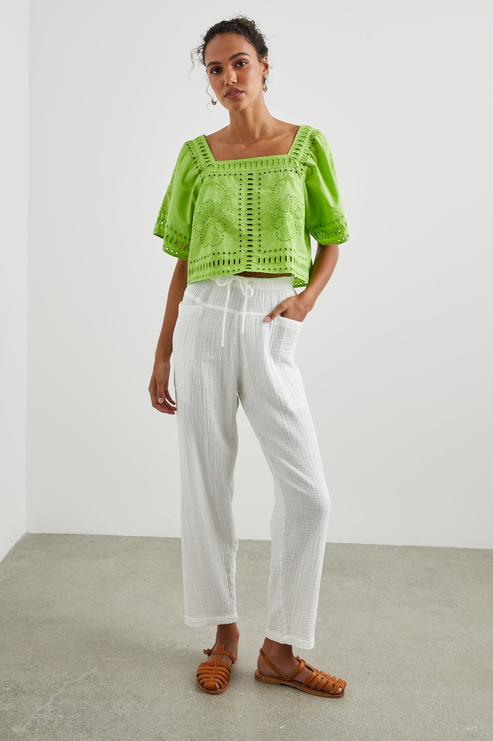 Laine Short Sleeve Crop Top with Square Neckline, and a Floral and Geometric Eyelet Design in Island Green Colorway - Front Full Body View Featured on Model