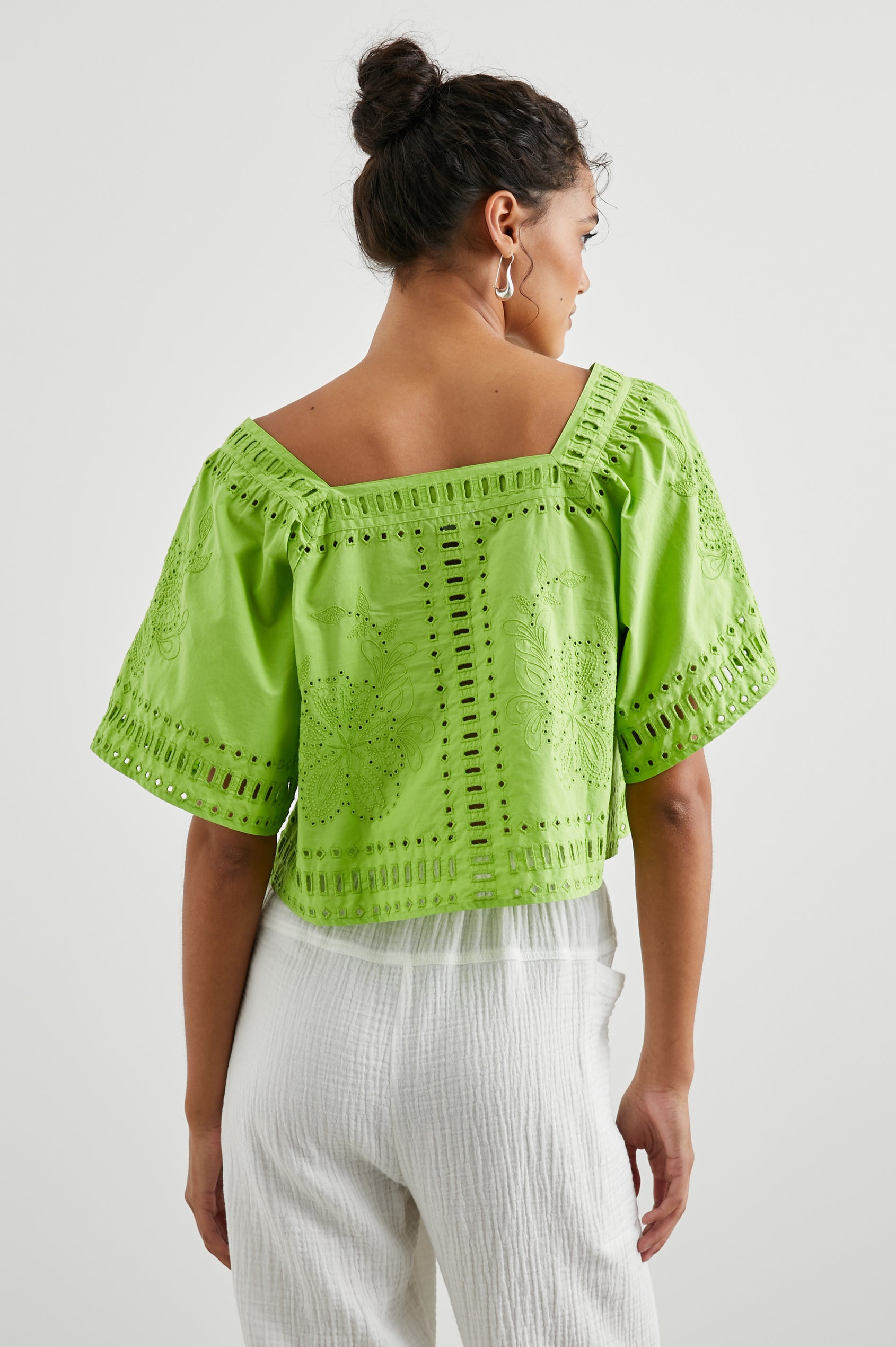 Laine Short Sleeve Crop Top with Square Neckline, and a Floral and Geometric Eyelet Design in Island Green Colorway - Front View Featured on Model
