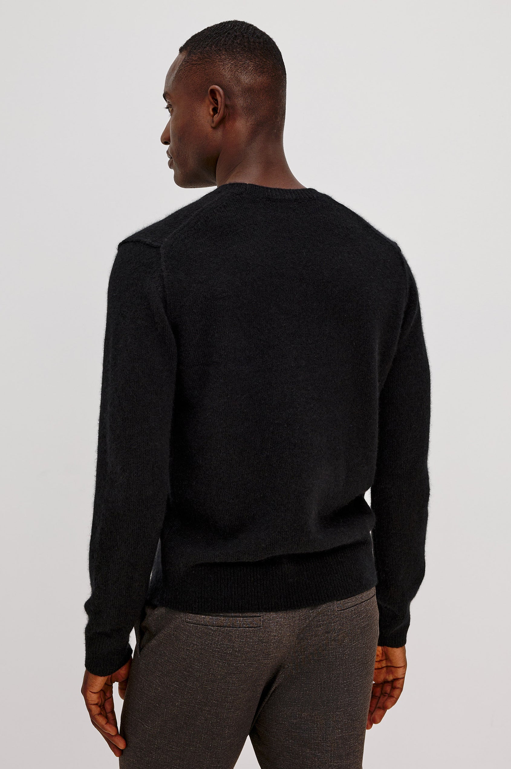Laurent Sweater in Merino Wool Cashmere Blend With Relaxed Fit, Reversed Linking Seams at Arm Holes, and Long Sleeves in Black Colorway - Upper Body Back View Featured on Model