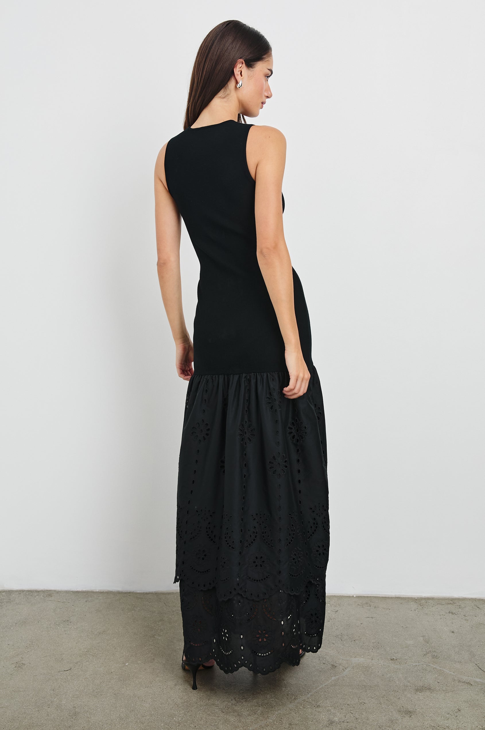 Lavina Crew Neck Tank Maxi Dress with Body Con Fitted Top Half and an Gathered Contrast Fabric Skirt with Embroidered Scallop Two Tier Hem in Black Colorway. Back View Shown on Model.