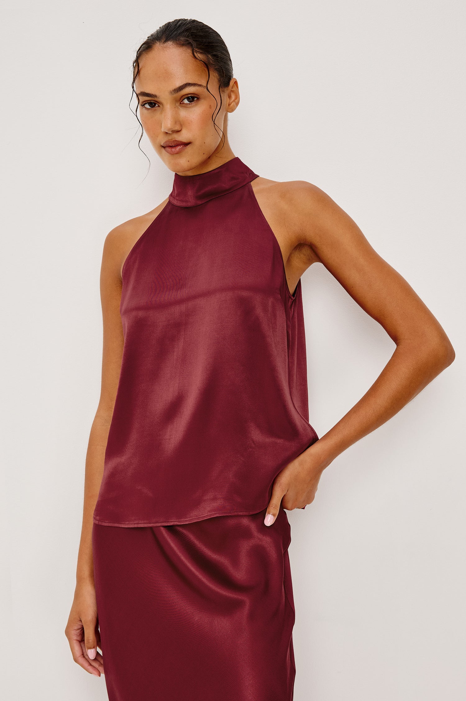 Leah Halter Top in Satin Crepe With a High Neckline, Sleevleless Cut, Back Button Neck Closure in Garnet Colorway - Upper Body Front View Featured on Model