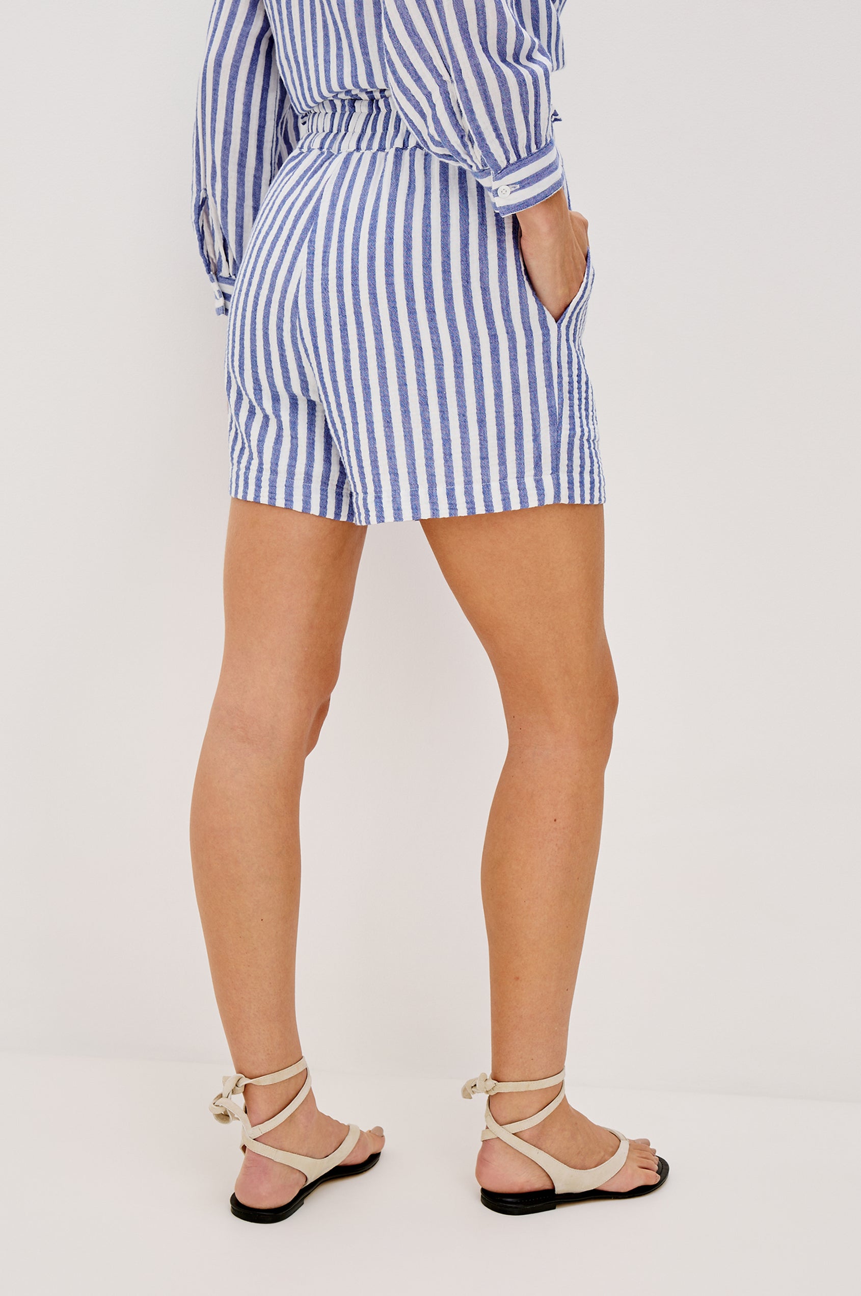 Leighton Shorts with Textured Fabric, a Smocked Elastic Waist, and Large Front Pockets in Anacapa Stripe Colorway, Blue and White Vertical Stripe - Back View Featured on Model