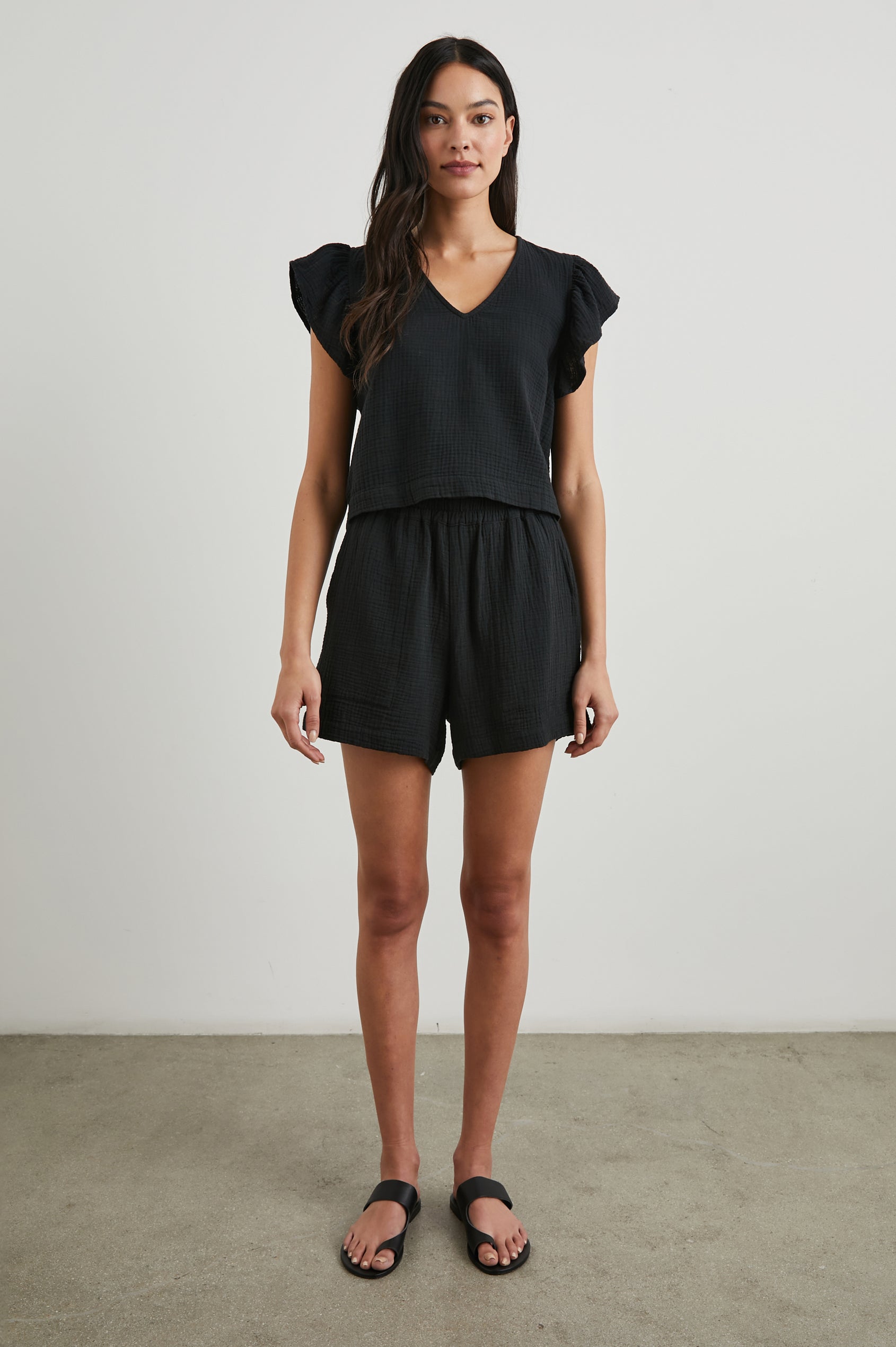 Leighton Shorts with Textured Fabric, a Smocked Elastic Waist, and Large Front Pockets in Black Colorway - Front Full Body View Featured on Model