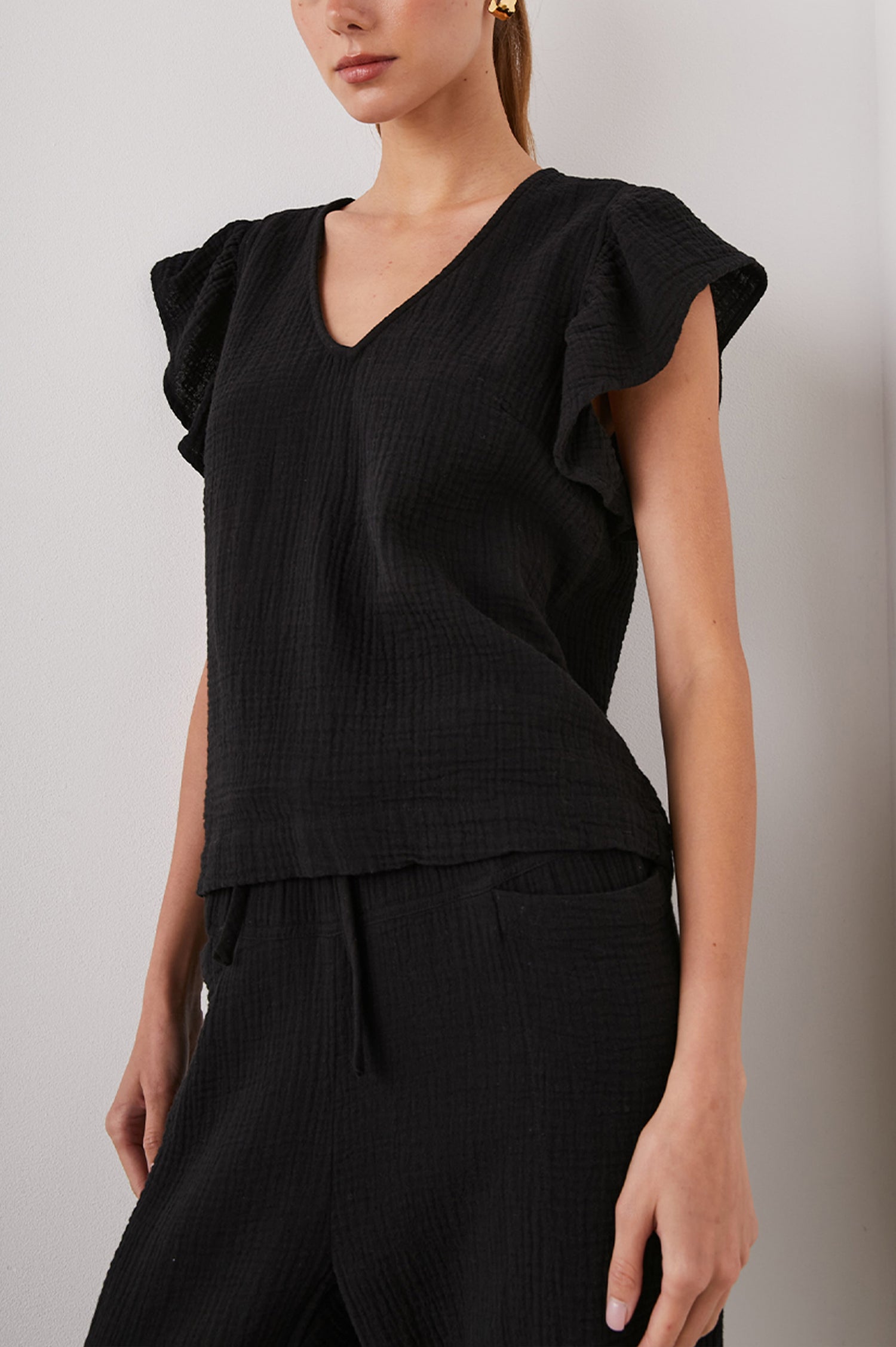 Lela Short-Sleeve Top with Flutter Sleeves and a V Neck in Black Colorway - Front View Featured on Model  