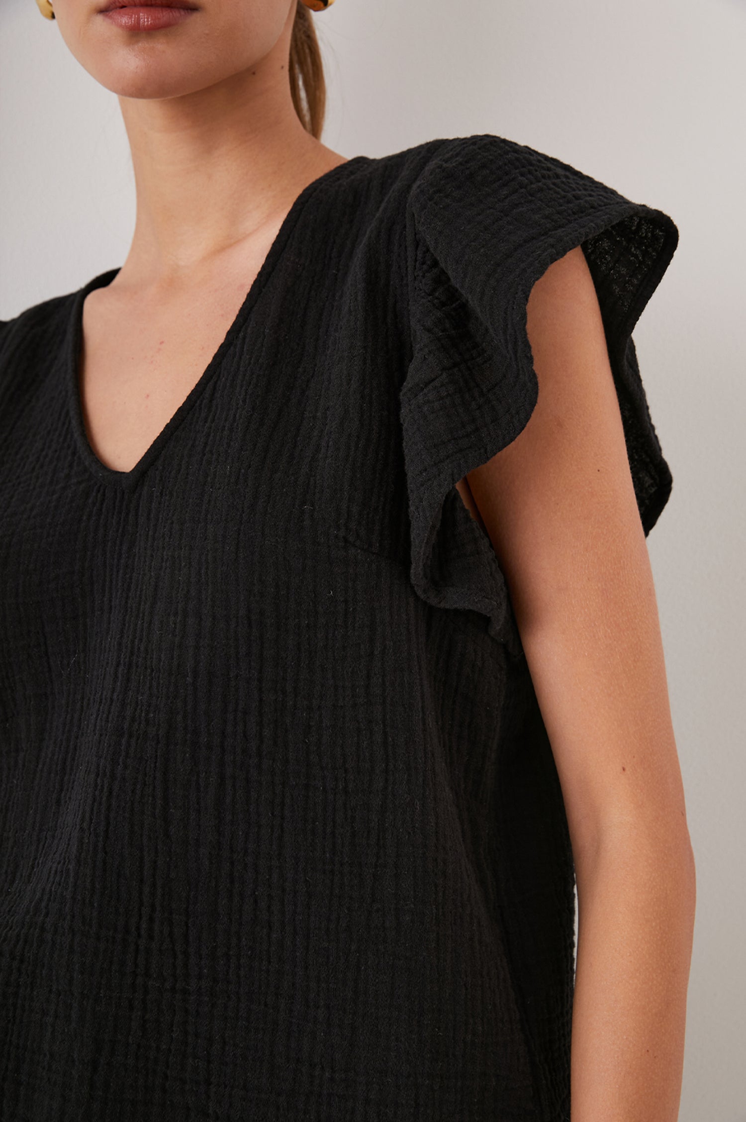 Lela Short-Sleeve Top with Flutter Sleeves and a V Neck in Black Colorway - Front View Featured on Model  