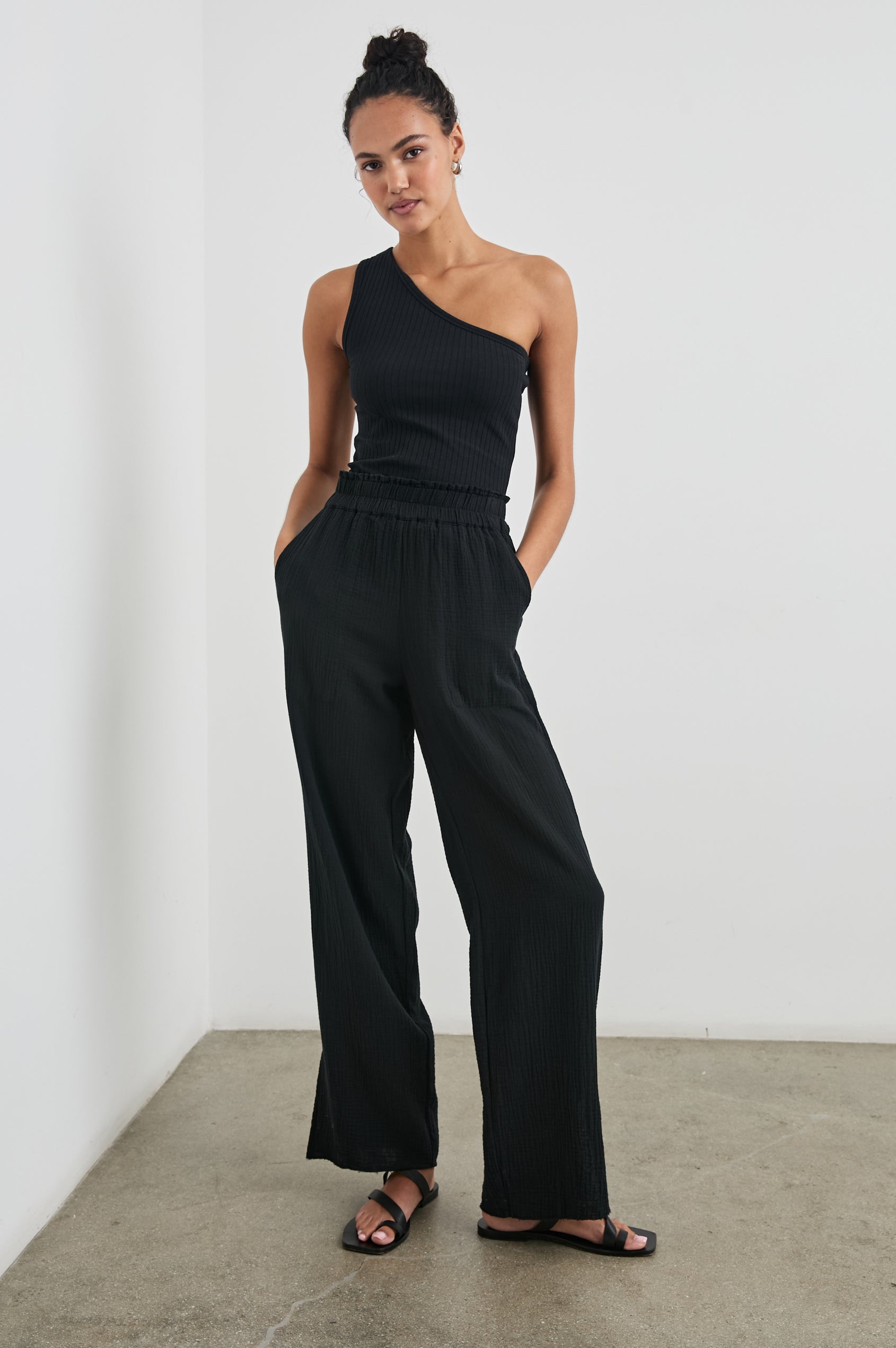 Leon Pant with a Smocked Waistband, Short Side Slits on Outer Leg and Two Front Seam Pockets in Black Colorway - Front Full Body View Featured on Model
