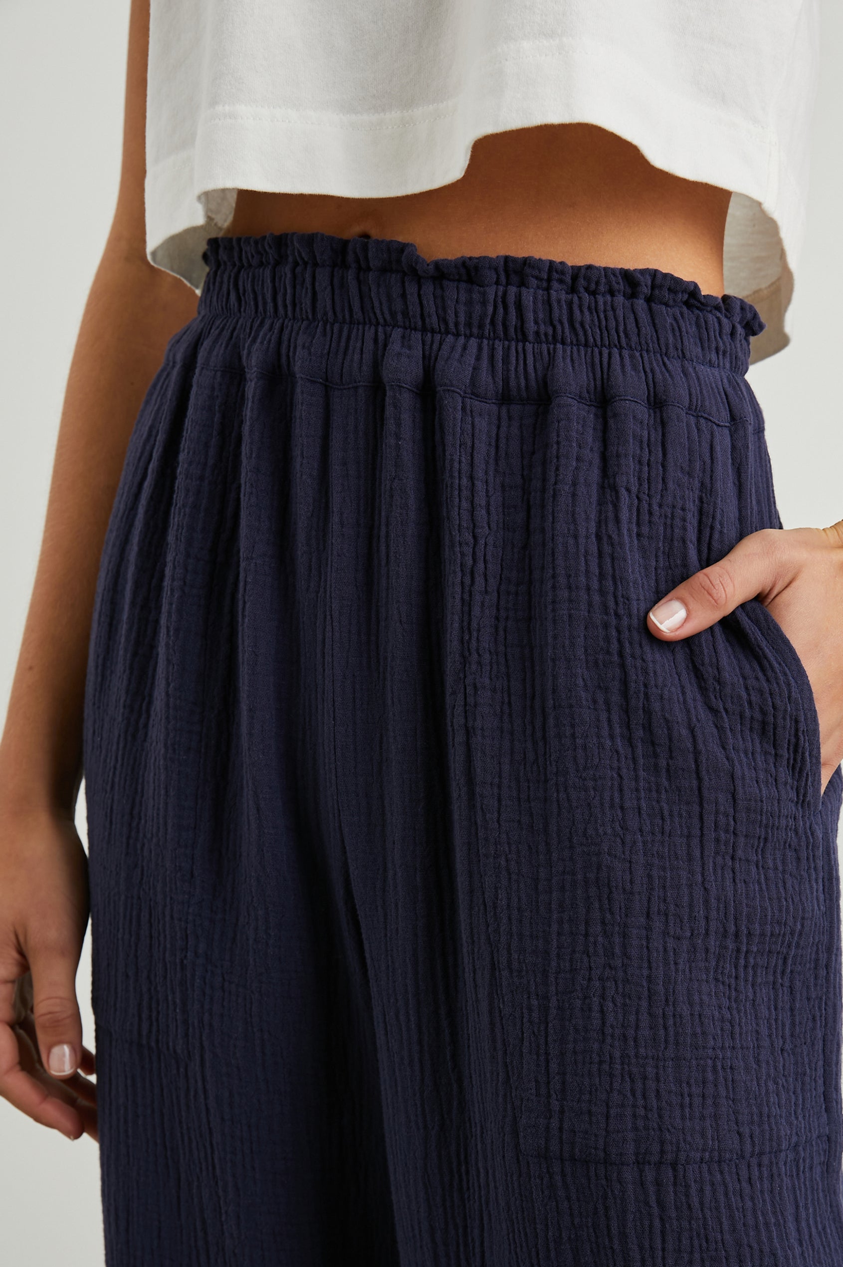 Leon Crop Pant with a Smocked Waistband and Two Front Seam Pockets in Navy Colorway - Front View Featured on Model
