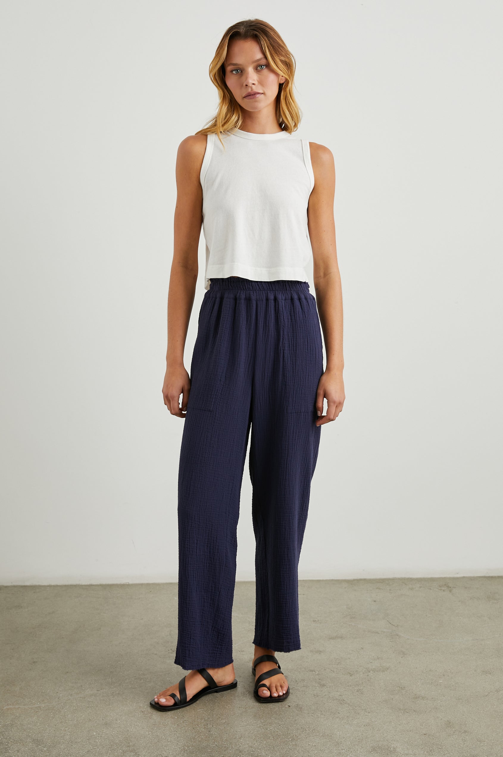 Leon Crop Pant with a Smocked Waistband and Two Front Seam Pockets in Navy Colorway - Front Full Body View Featured on Model