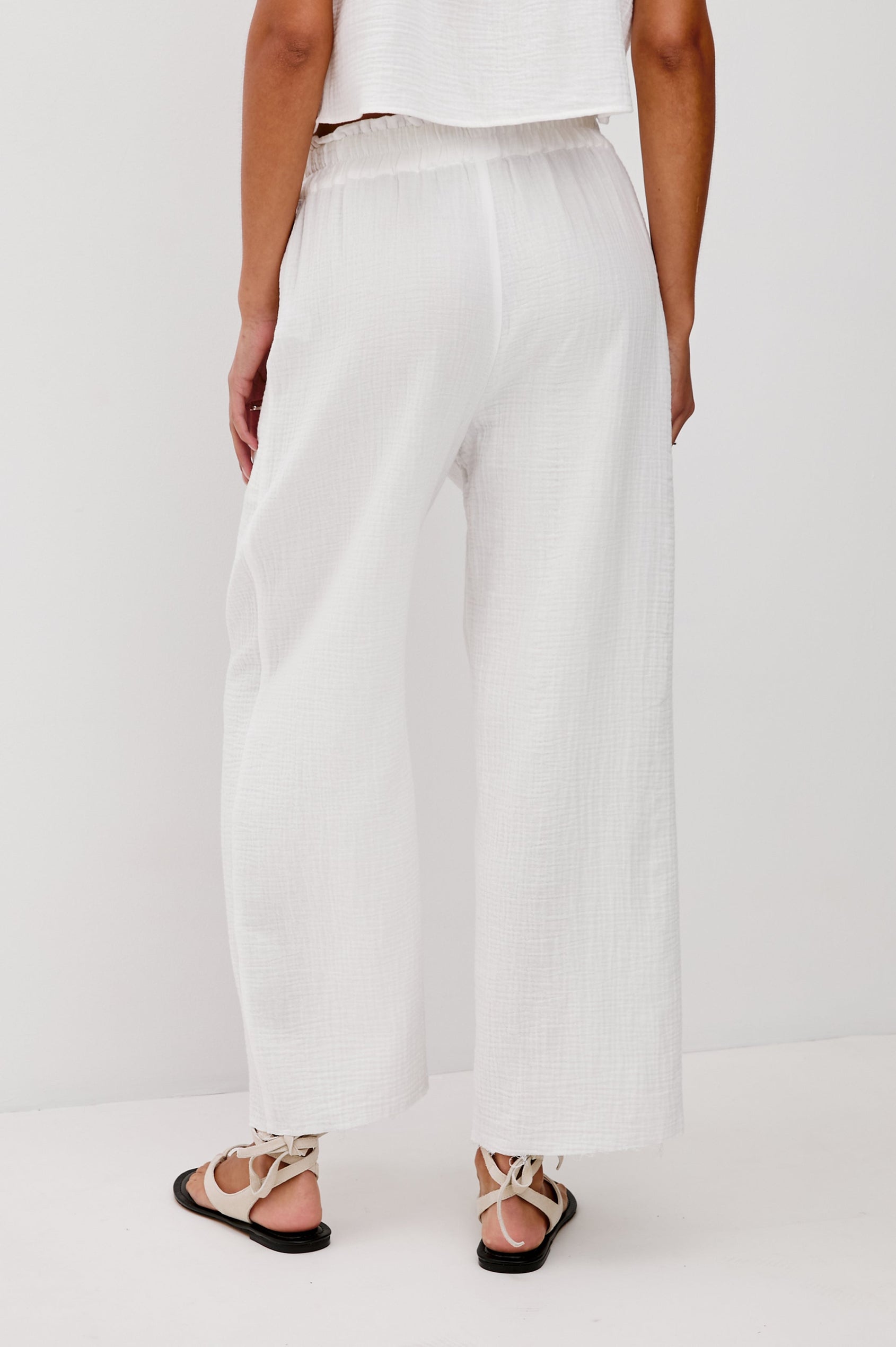 Leon Crop Cotton Gauze Pant With Hemline Slit And Elastic Waist In Colorway White - Back View Featured On Model