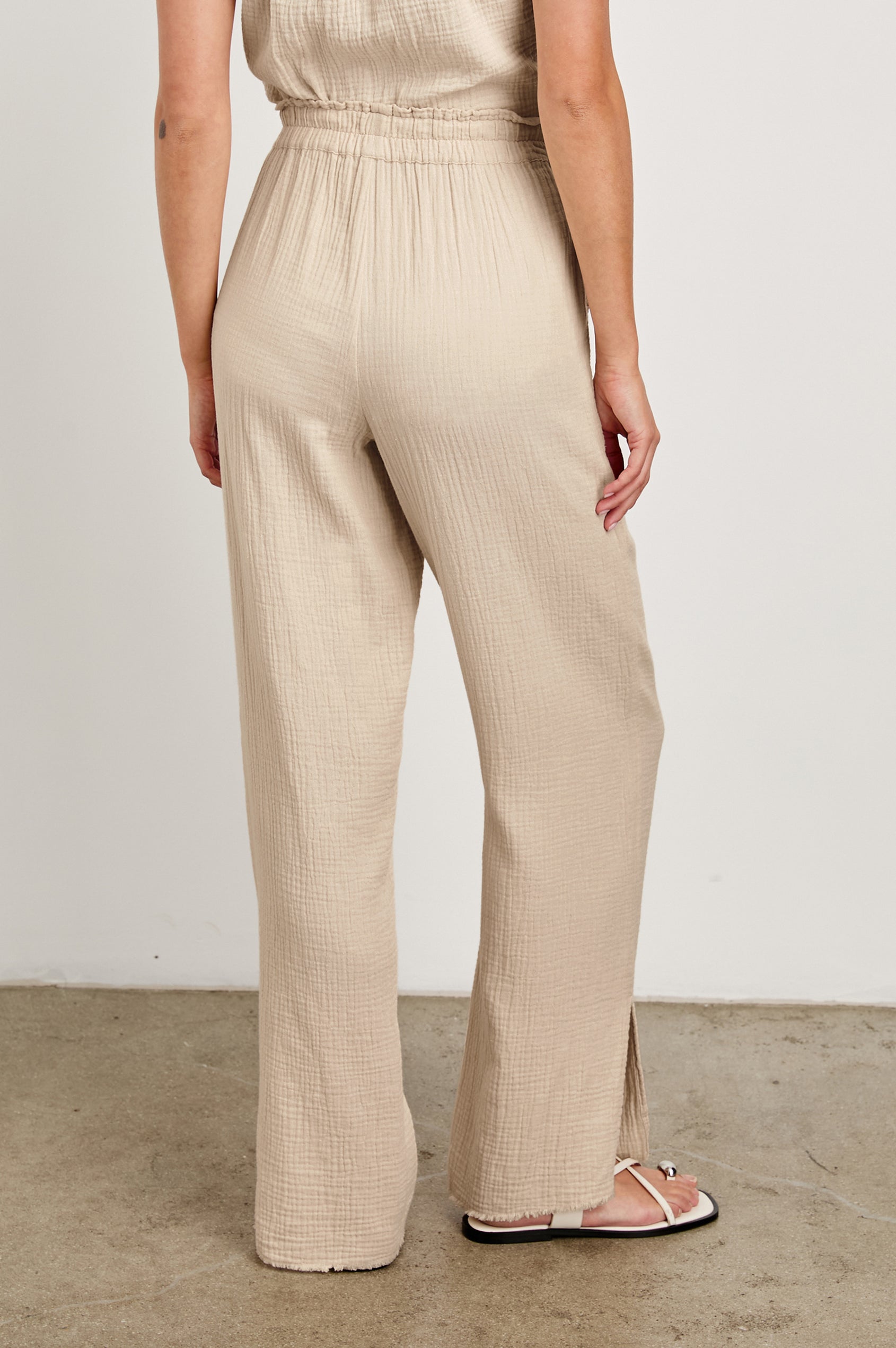 Leon Cotton Gauze Pant With Hemline Slit And Elastic Waist In Colorway Flax -  Back View Featured On Model