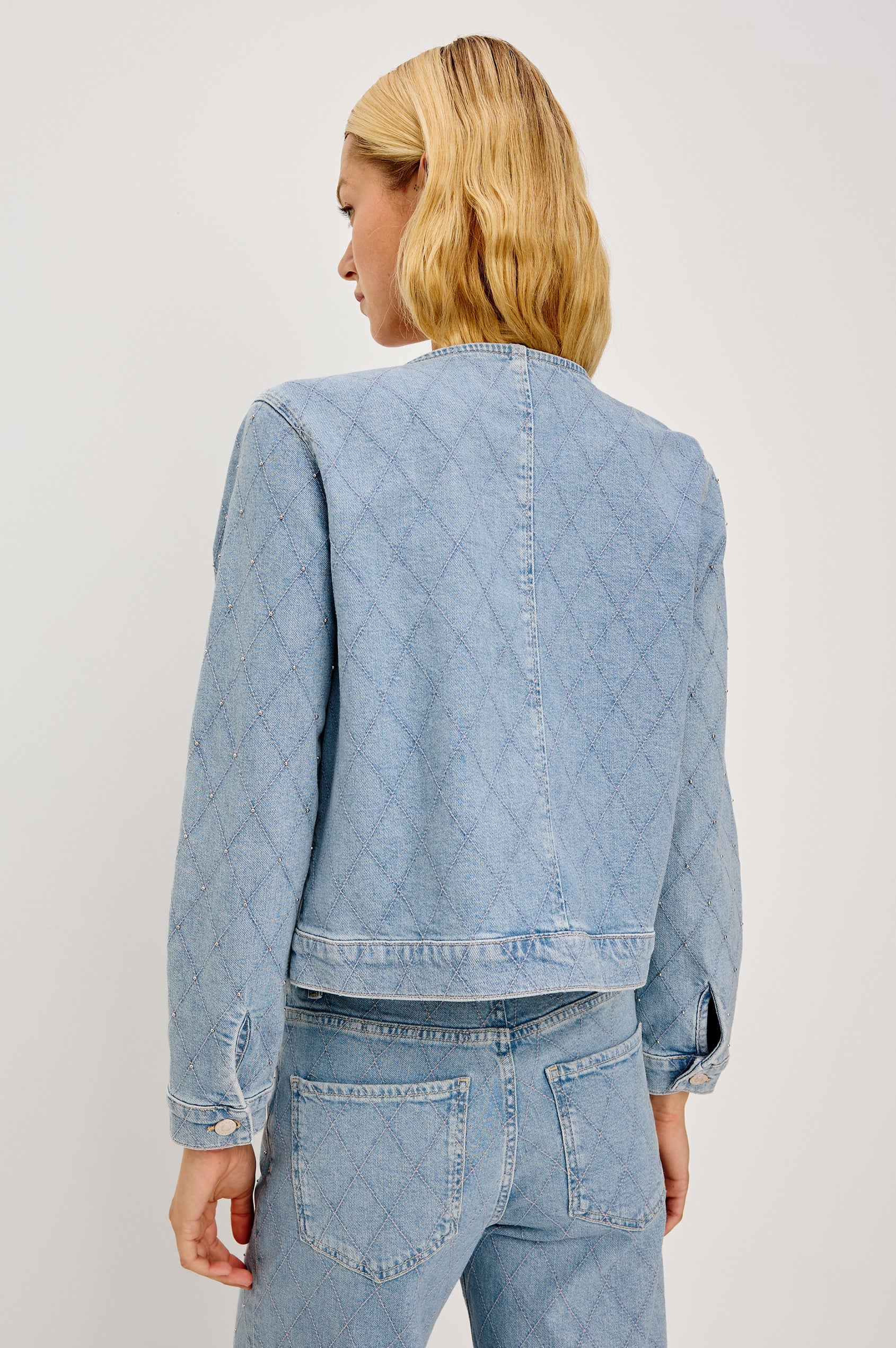 Lido Lady Jacket in Light Stretch Denim With Cropped Boxy Fit, Collarless Neckline, Front Buttons, Long Sleeves, and Chest Patch Pockets in Quilted Stud Colorway - Upper Body Back View Featured on Model