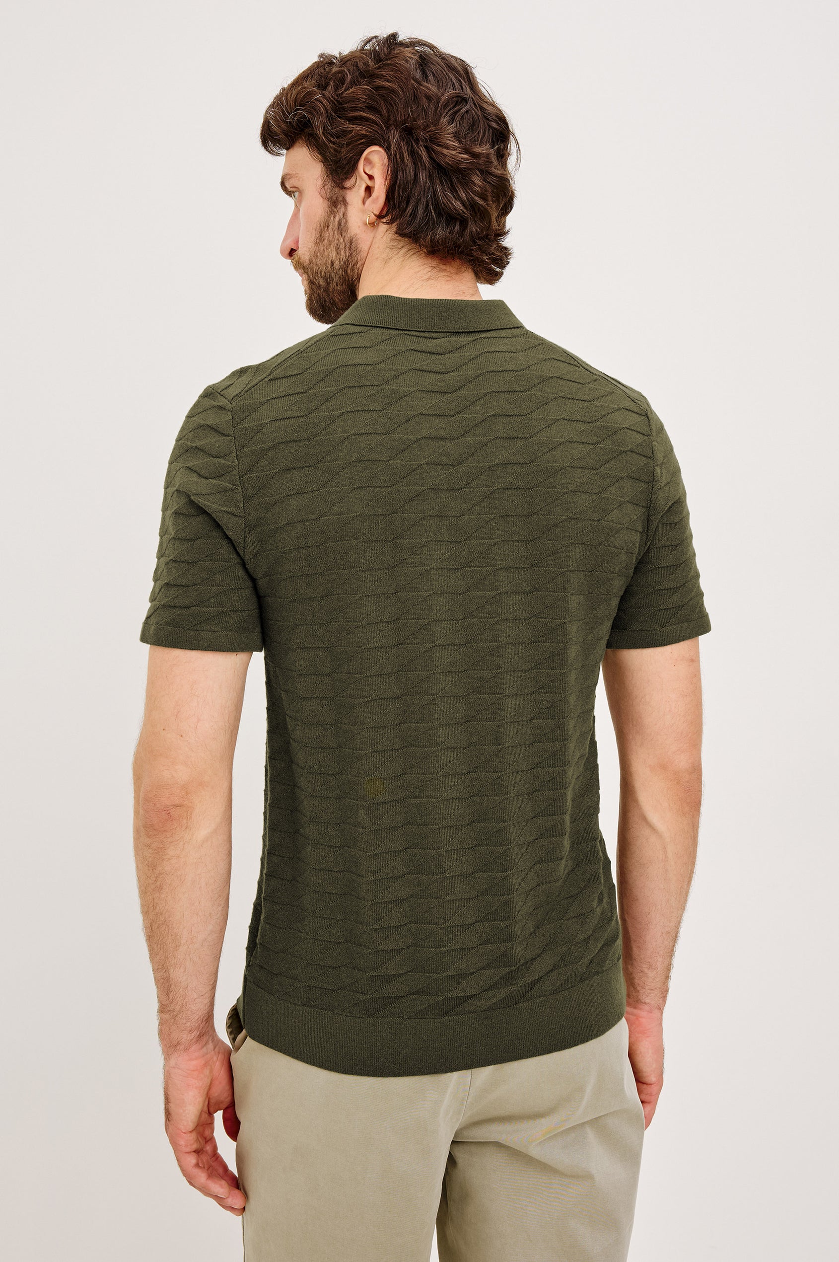 Linden Polo Shirt in Cotton Knit With Subtle Diamond Texture, Classic Fit, Quarter Button Placket, Short Sleeves, and Ribbed Trim in Ancient Olive Prism Colorway - Upper Body Back View Featured on Model