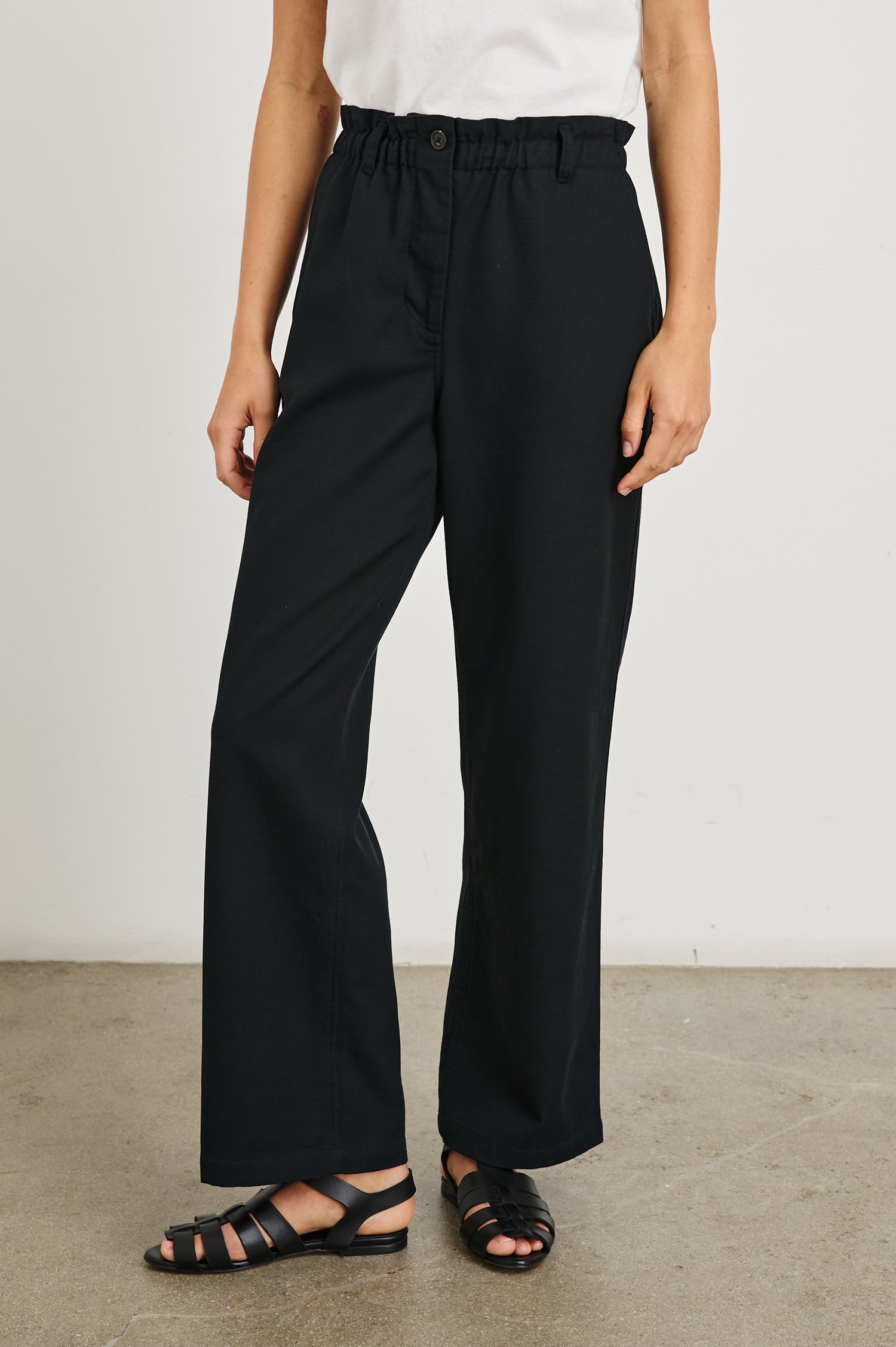 Lira Pants with a Paperbag Elastic Waist, Belt Loops, Two Front Pockets and Two Back Welt Pockets in Black Colorway - Front View Featured on Model 