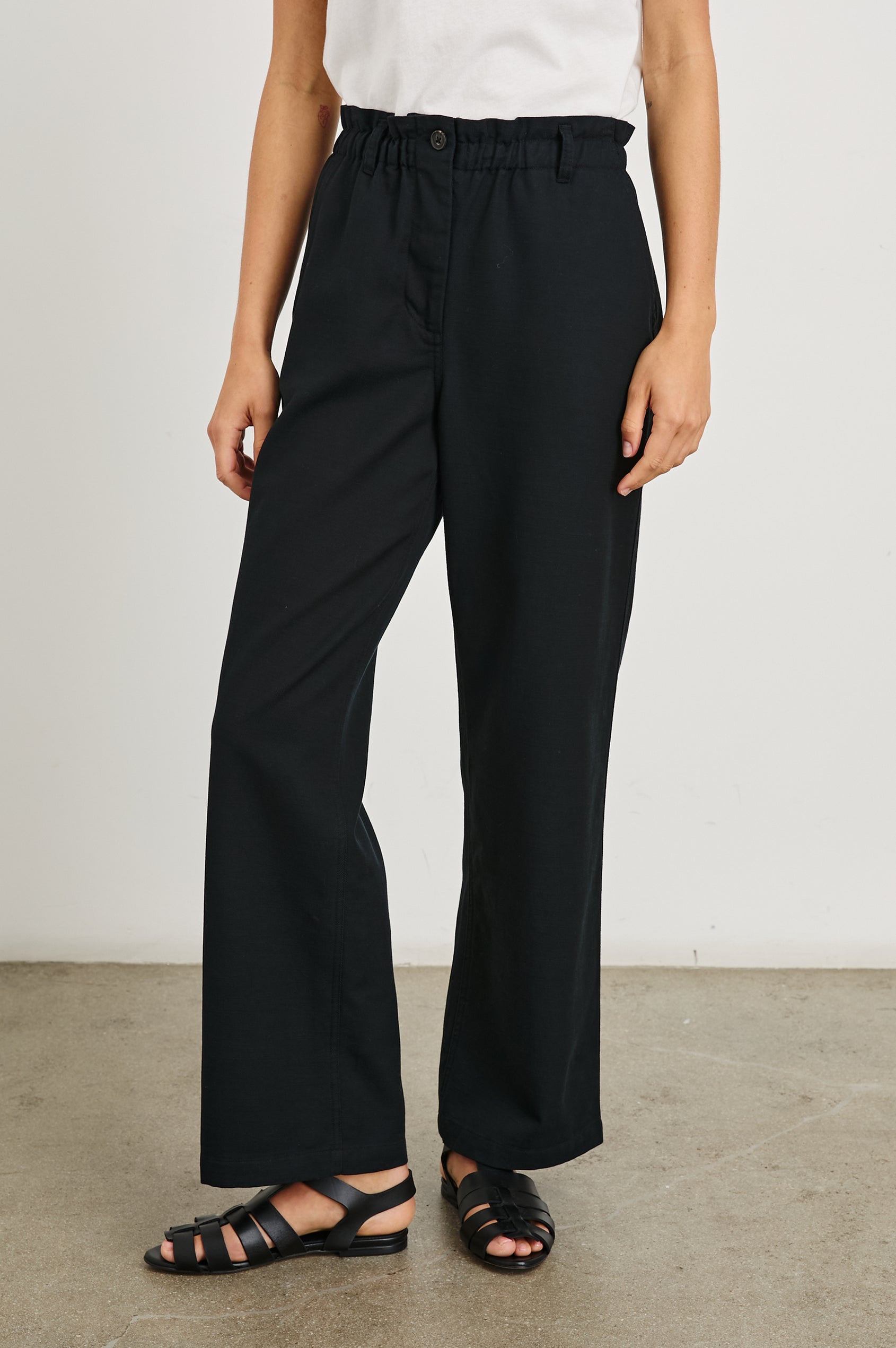 Lira Pants with a Paperbag Elastic Waist, Belt Loops, Two Front Pockets and Two Back Welt Pockets in Black Colorway - Front View Featured on Model 