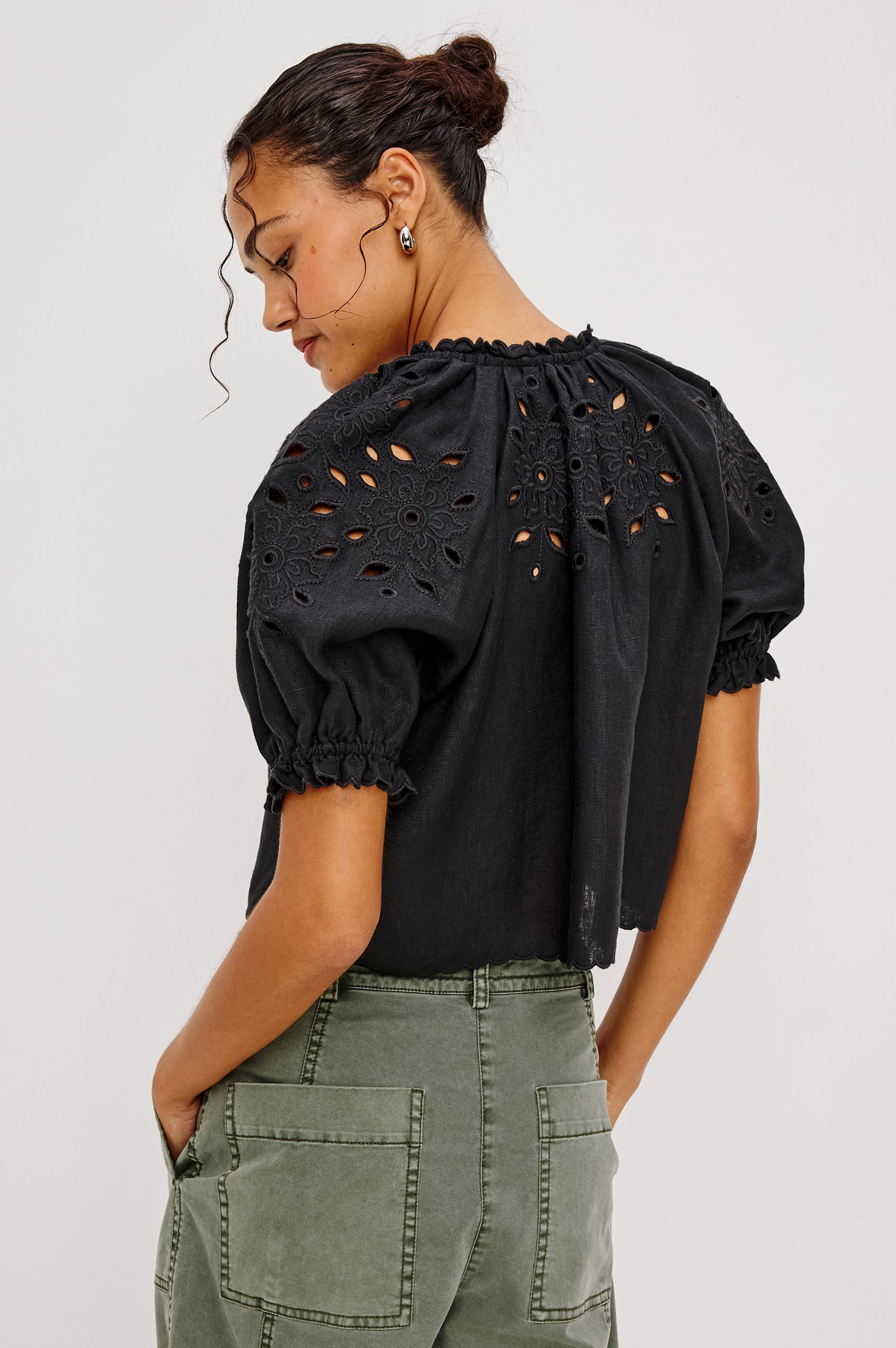 Lizbeth Milkmaid Top in Linen With Floral Eyelet Cutwork, Plunging Tie-Front V-Neckline, Front Ties, Relaxed FIt, Short Puff Sleeves in Black Ctolorway - Upper Body Back View Featured on Model