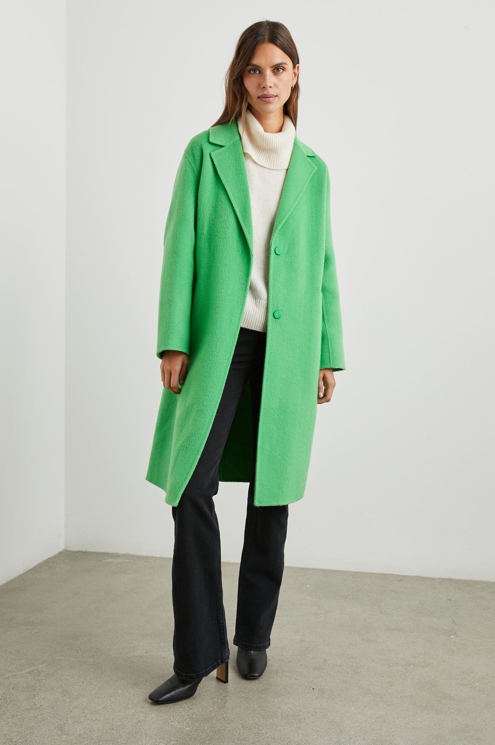 Lore Knee-Length Coat with Two Button Closure, Notched Lapels and Two Front Pockets in Green Apple Colorway - Front Full Body View Featured on Model