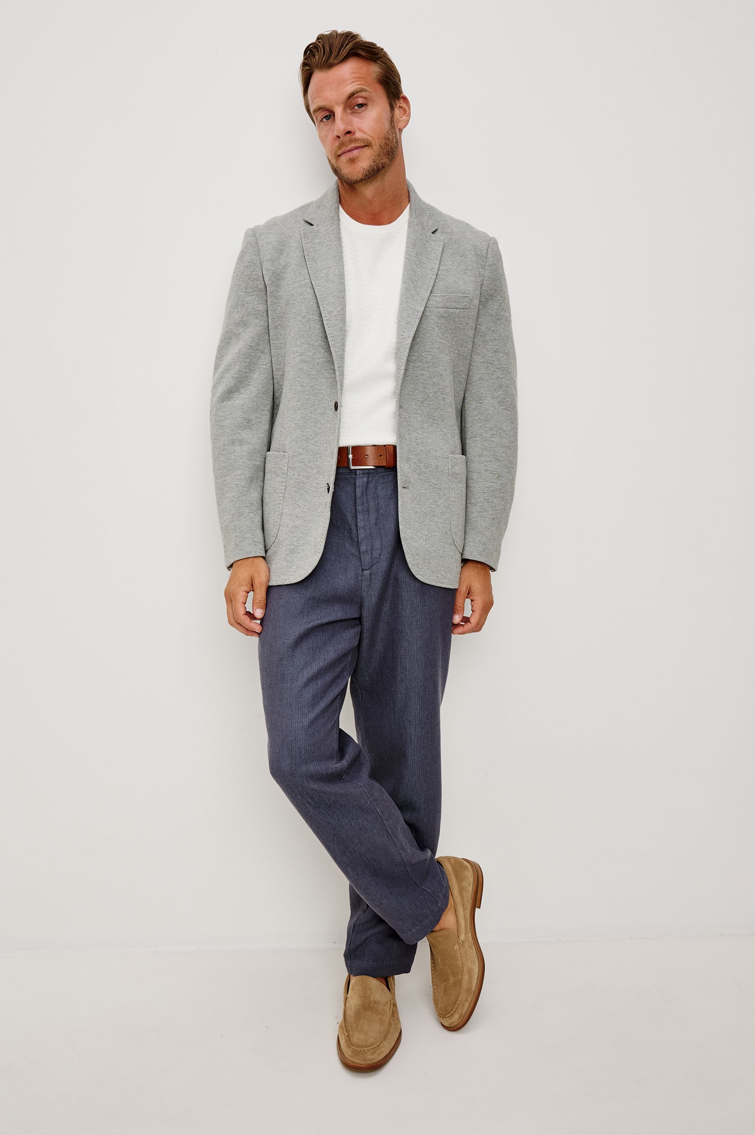 Lorenz Blazer in Cotton Blend With Notched Lapels, Long Sleeves, Front Buttons, Chest Pocket, and SIde Patch Pockets in Heather Grey Colorway - Full Body Front View Featured on Model
