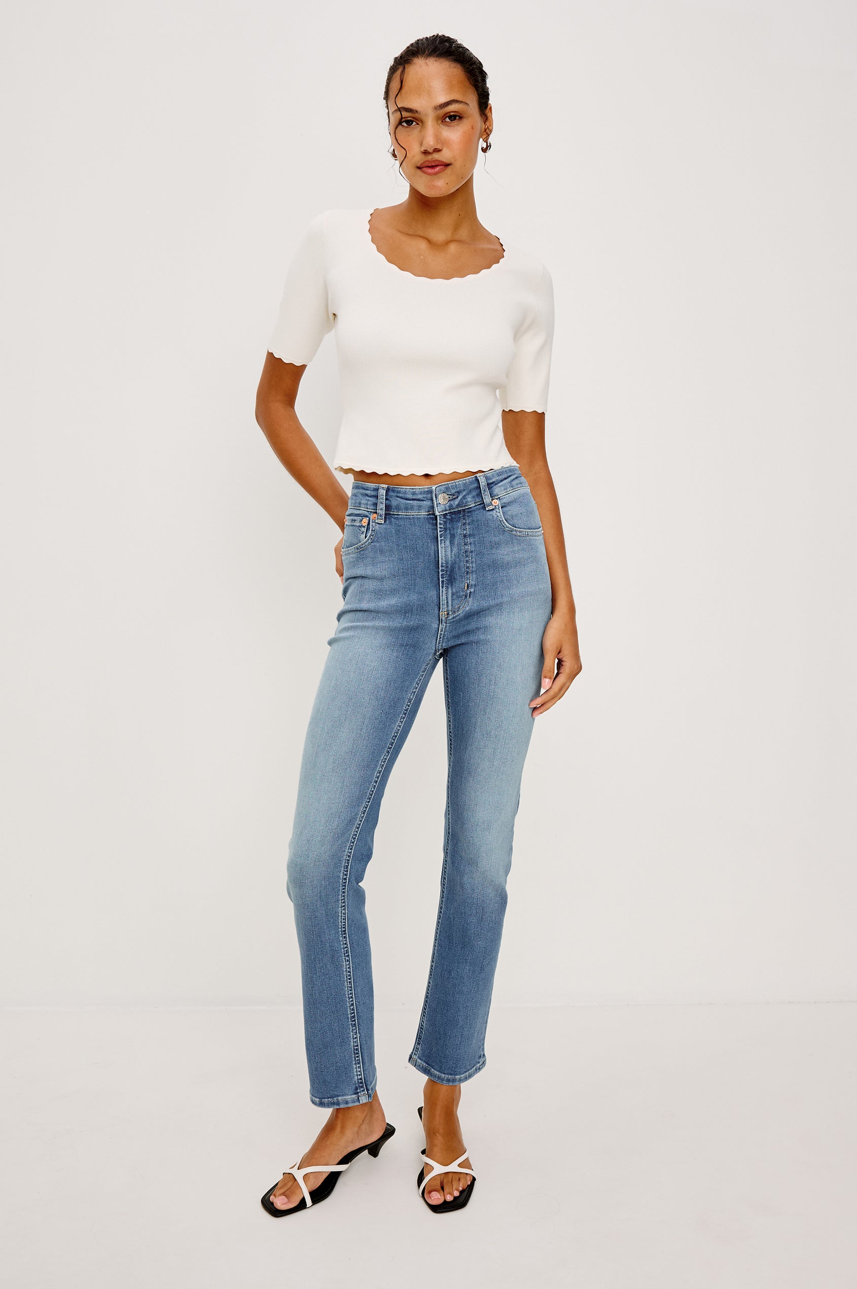 Louanna Fitted Cropped Top in Compact Knit With Scallop-Trimmed Scoop Neckline Short Sleeves and Hem in Ivory Colorway - Full Body Front View Featured on Model