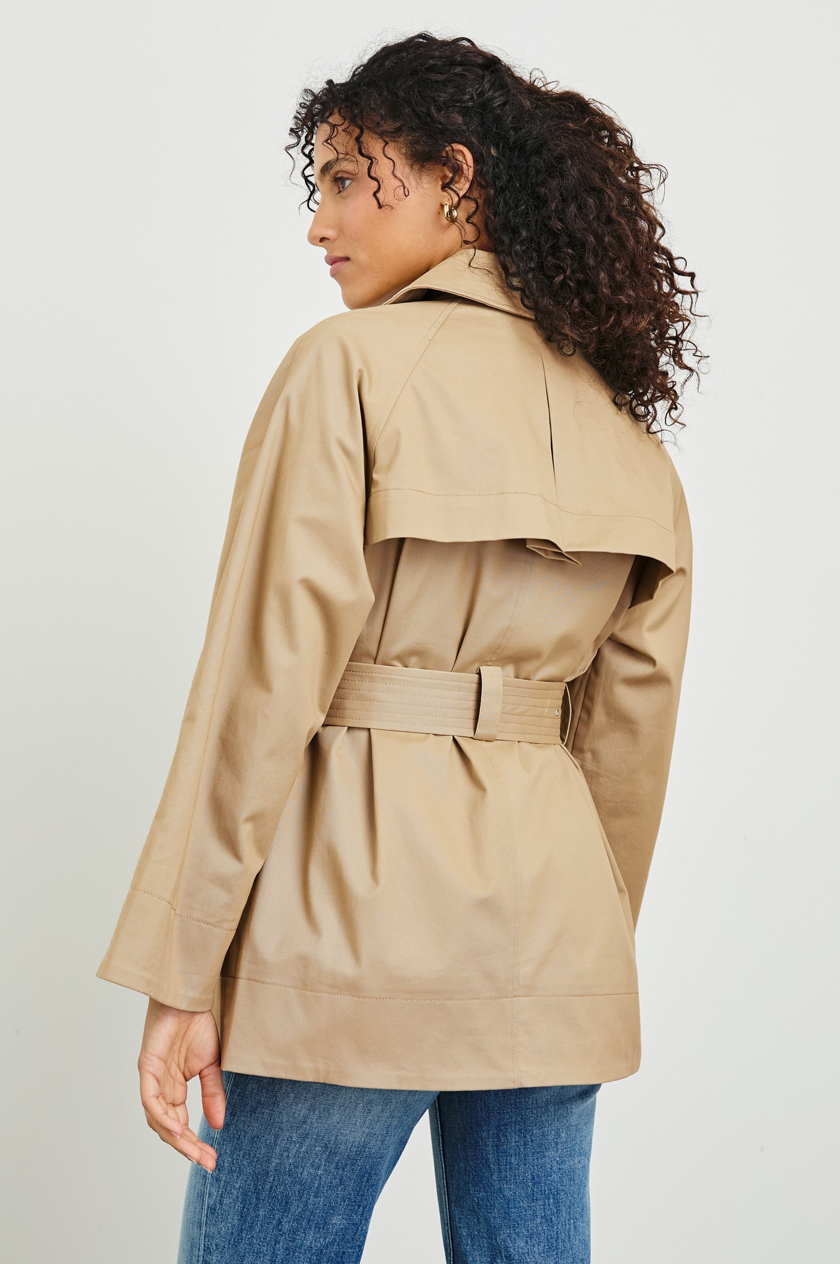 Lucien Trench Jacket with a Belt at the Waist, Button Closure and Two Front Pockets in Taupe Colorway with Dark Brown Buttons - Back View Featured on Model