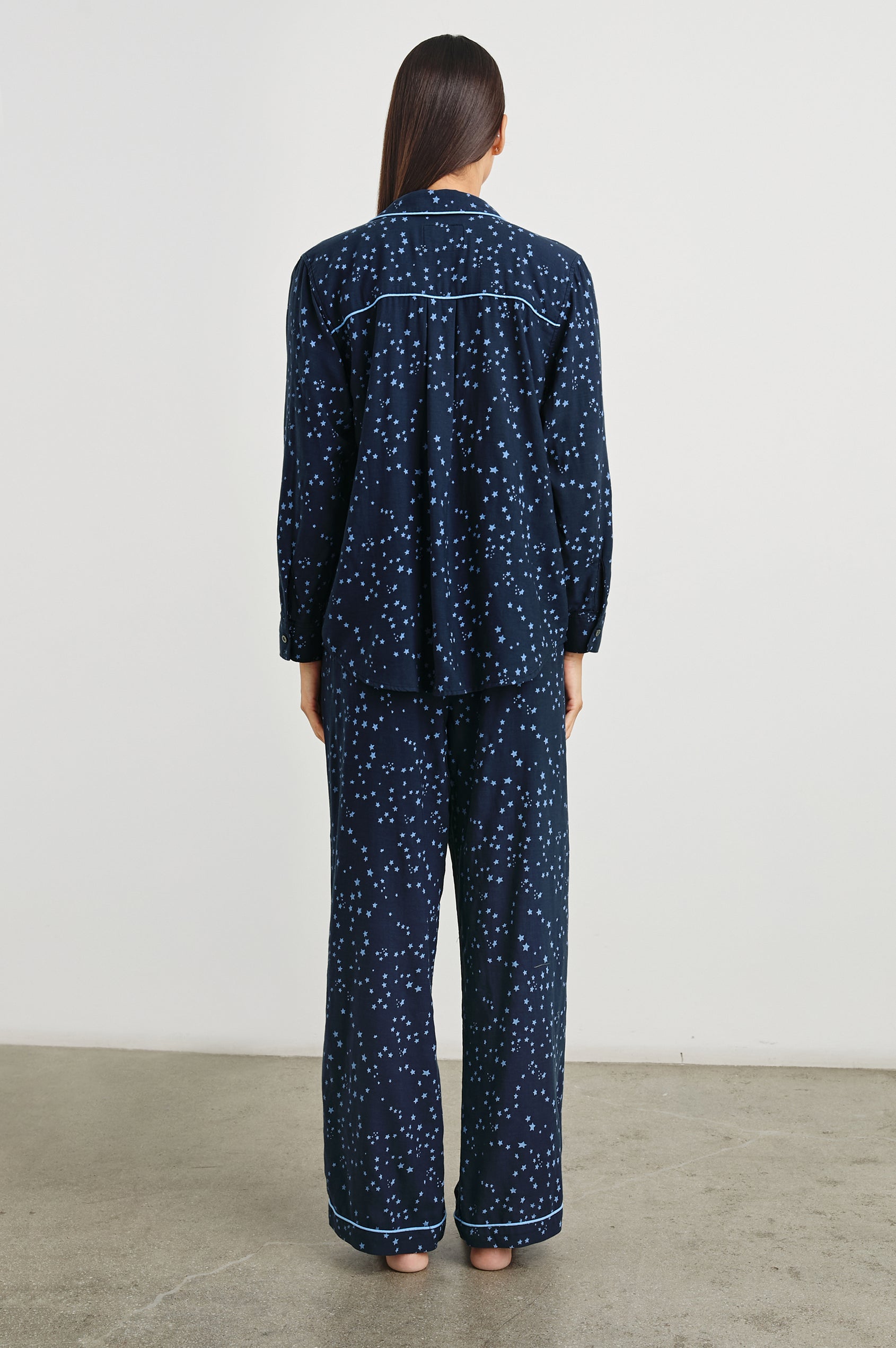 Luna Pajama Set with a Long Sleeve, Button Up, V Neck Top with a Chest Patch Pocket and Pants with Two Front Pockets in Stellar Colorway, blue starts on Dark Blue - Back Full Body View Featured on Model  