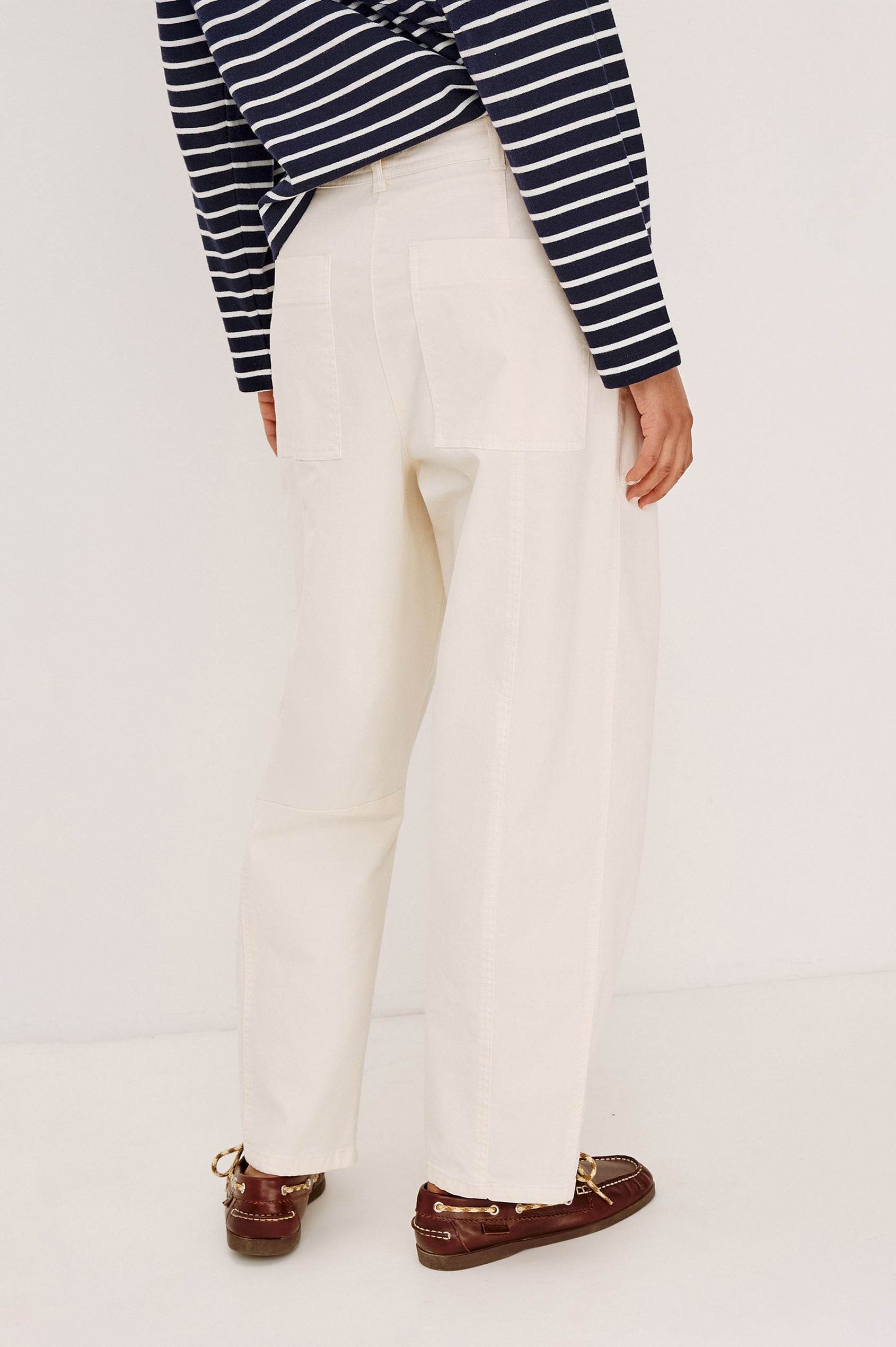 Lunar Pant in Stretch Corduroy With Relaxed Straight Legs, Zip-Fly Closure, Belt Loops, Seam Detailing, Carpenter-Style Side Pockets, and Back Pockets in Bone Colorway - Lower Body Back View Featured on Model