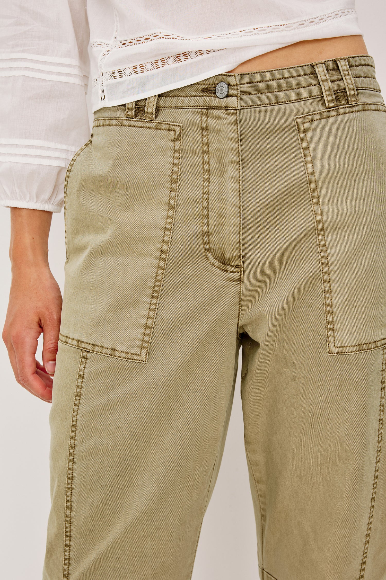 Mid-rise, barrel-leg pants made from stretch twill in Light Olive colorway. The pants have knee seaming, front pockets, a zip fly, and an adjustable drawstring waist for a casual, comfortable fit. Close up of details on model.