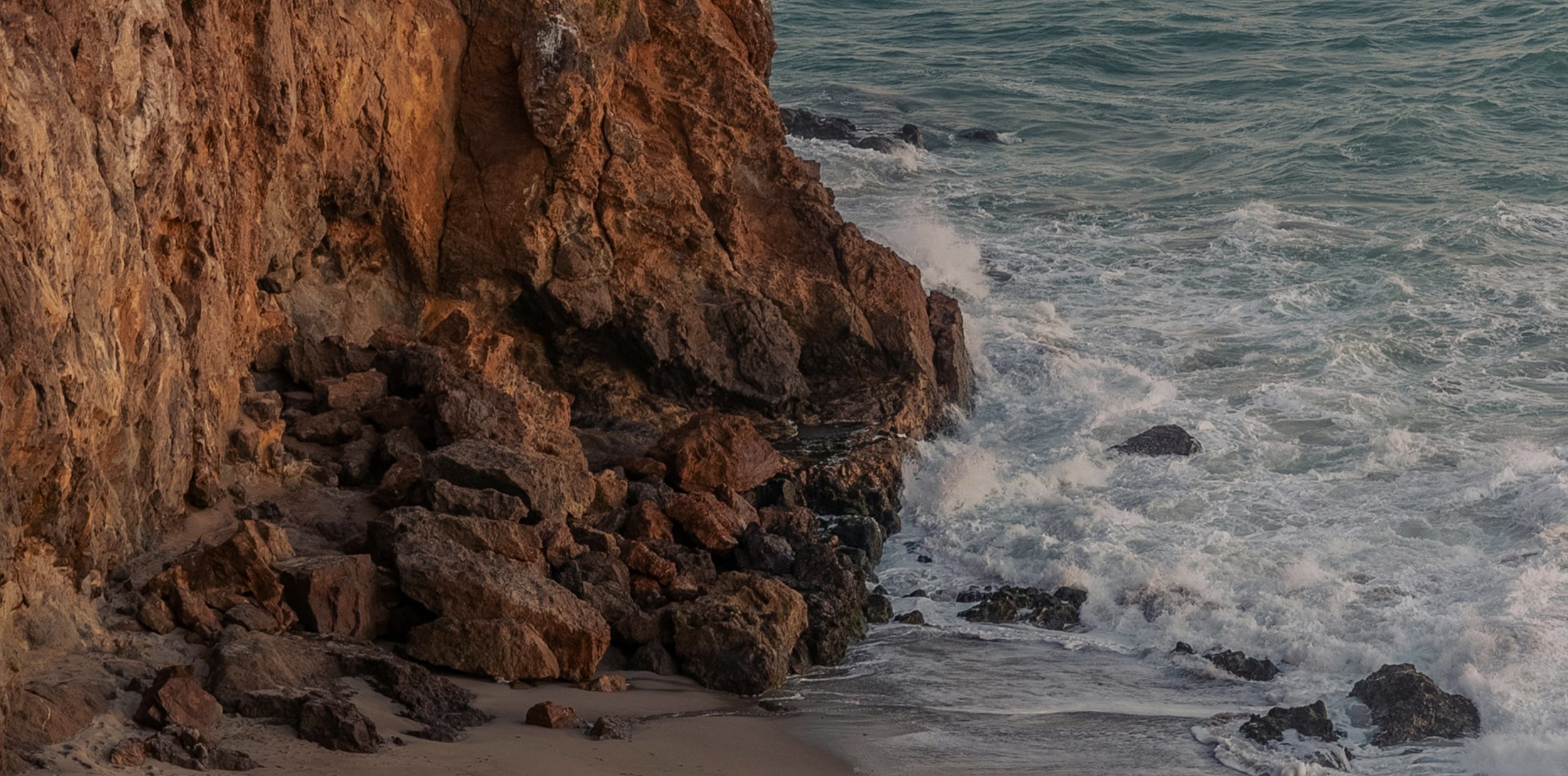 Rocks by the ocean with waves crashing against them