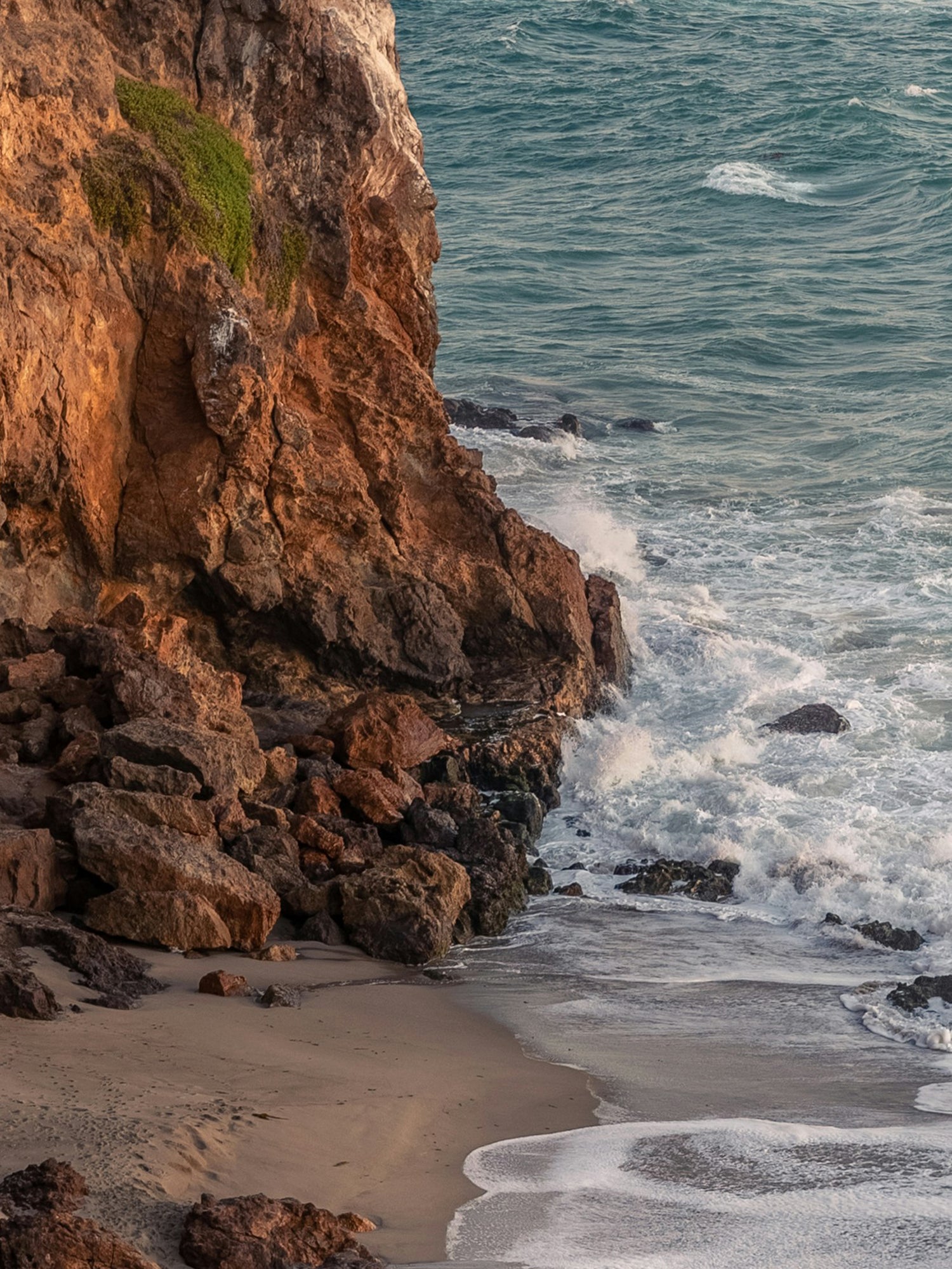 Rugged coastline with rocky cliffs and crashing waves.