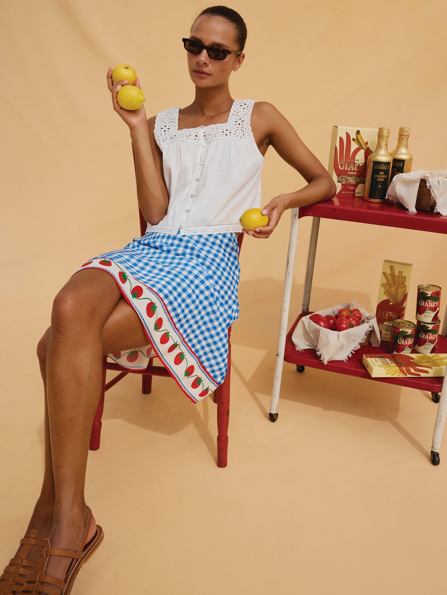 Woman in a white top and tomato gingham skirt
