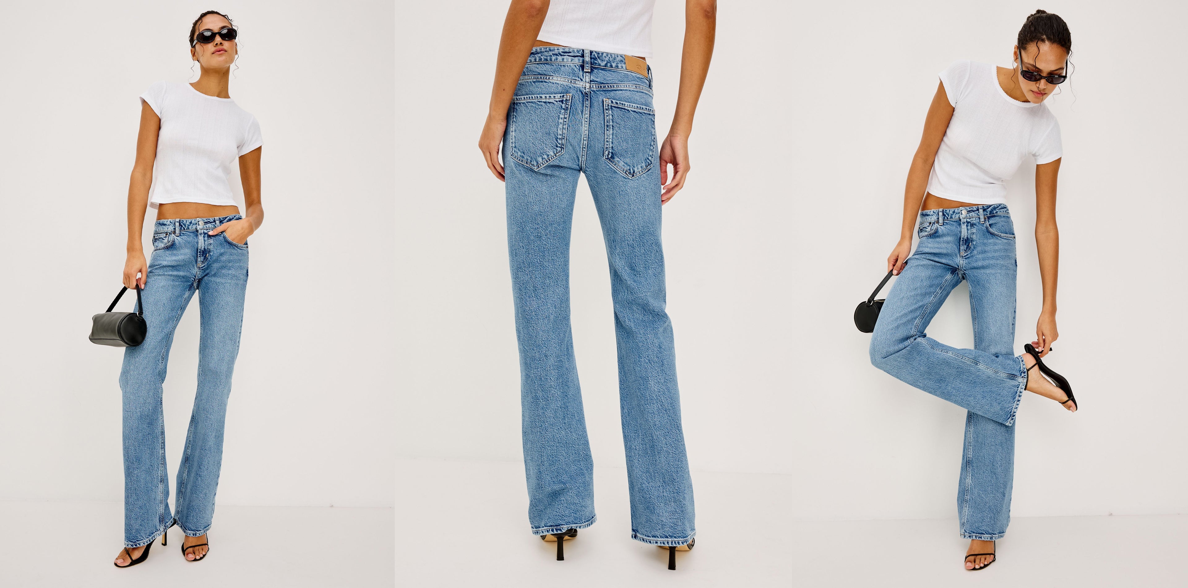 Woman wearing light blue jeans and a white top, posing against a white background.