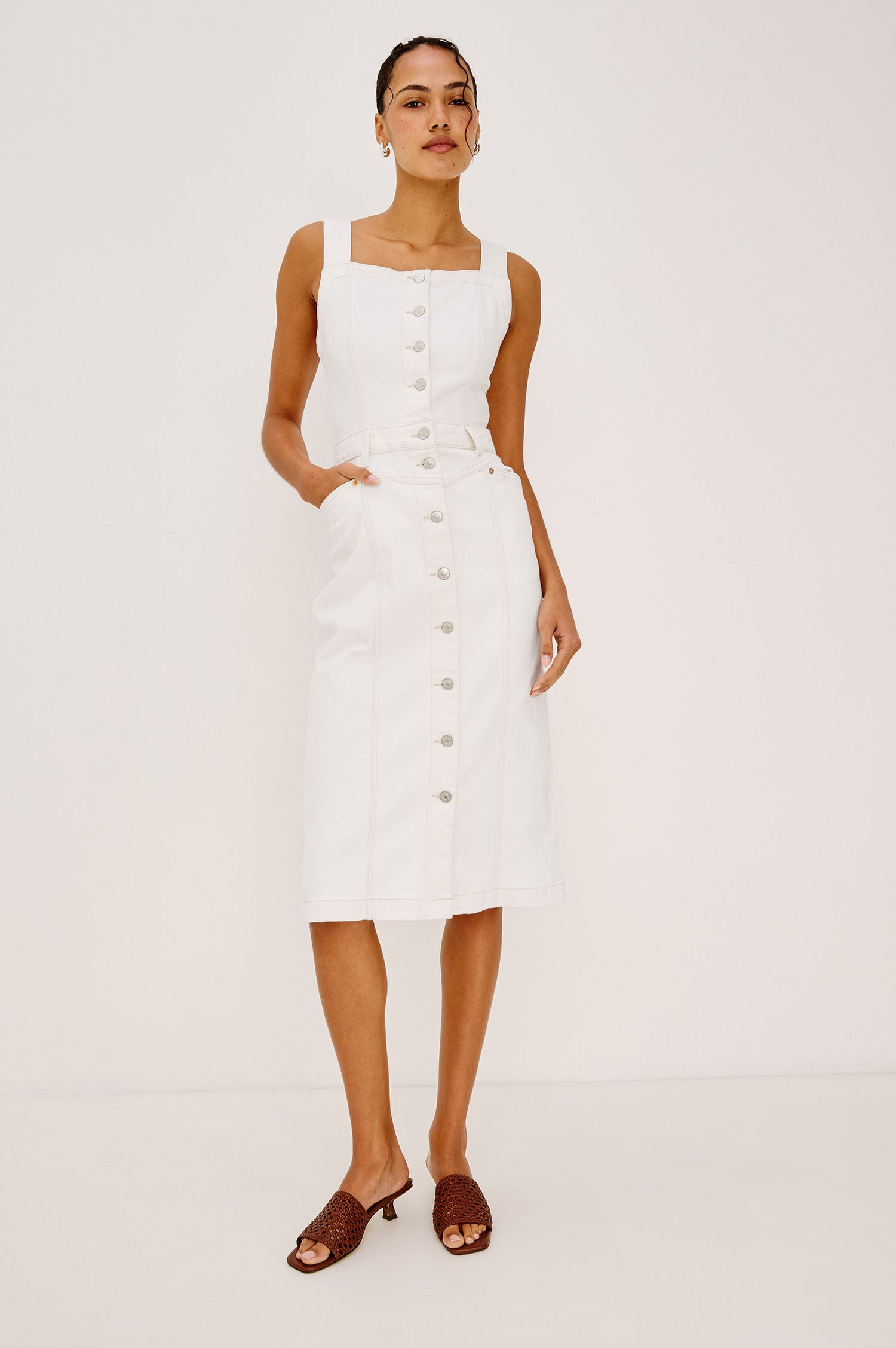 Malibu Sleeveless Denim Midi Dress with Shoulder Straps, Buttons Down the Front, a Square Neckline in the Front and Back, Two Front Pockets and Two Back Patch Pockets in Vintage Ecru Colorway - Front View Featured on Model