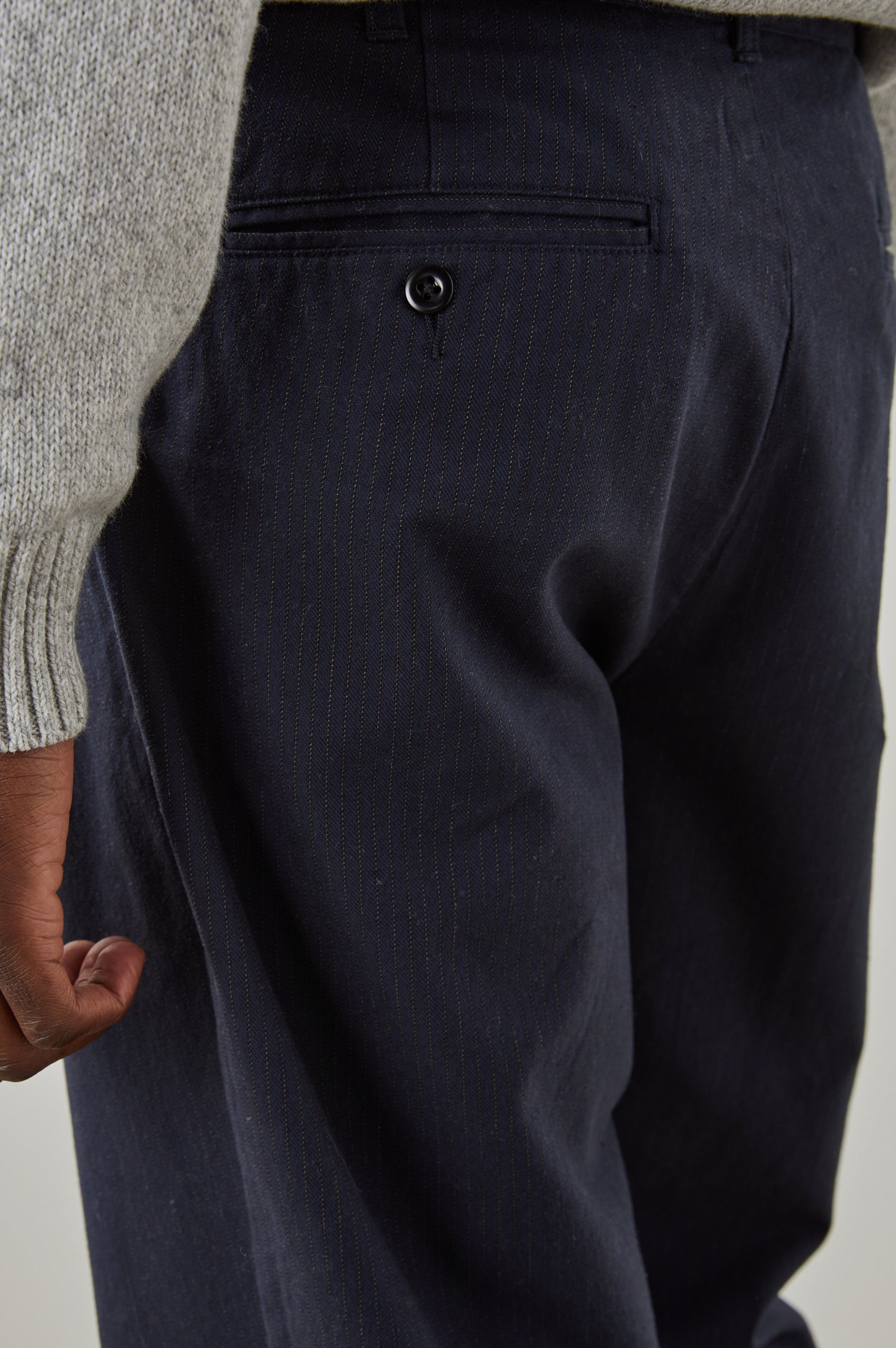 Marcellus Pants with Belt Loops, Two Seam Front Pockets, a Front Buttoned Flap Pocket, a Back Buttoned Welt Pocket and a Back Welt Pocket in Navy Charcoal Pin Stripe Colorway - Back View Featured on Model 