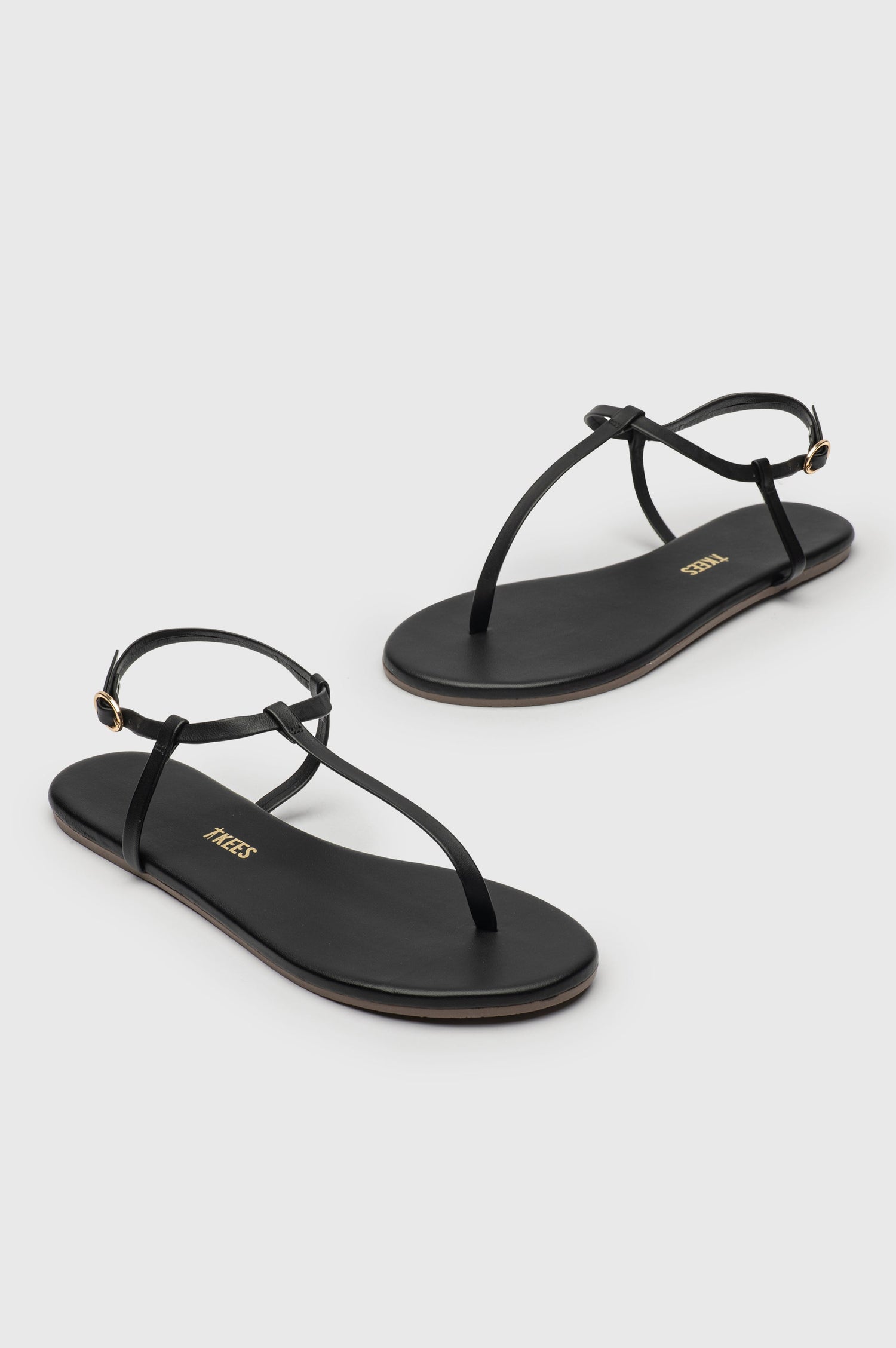 Mariana leather t-strap sandal with ankle strap and buckle in Sable black - cross angled view of pair of shoes
