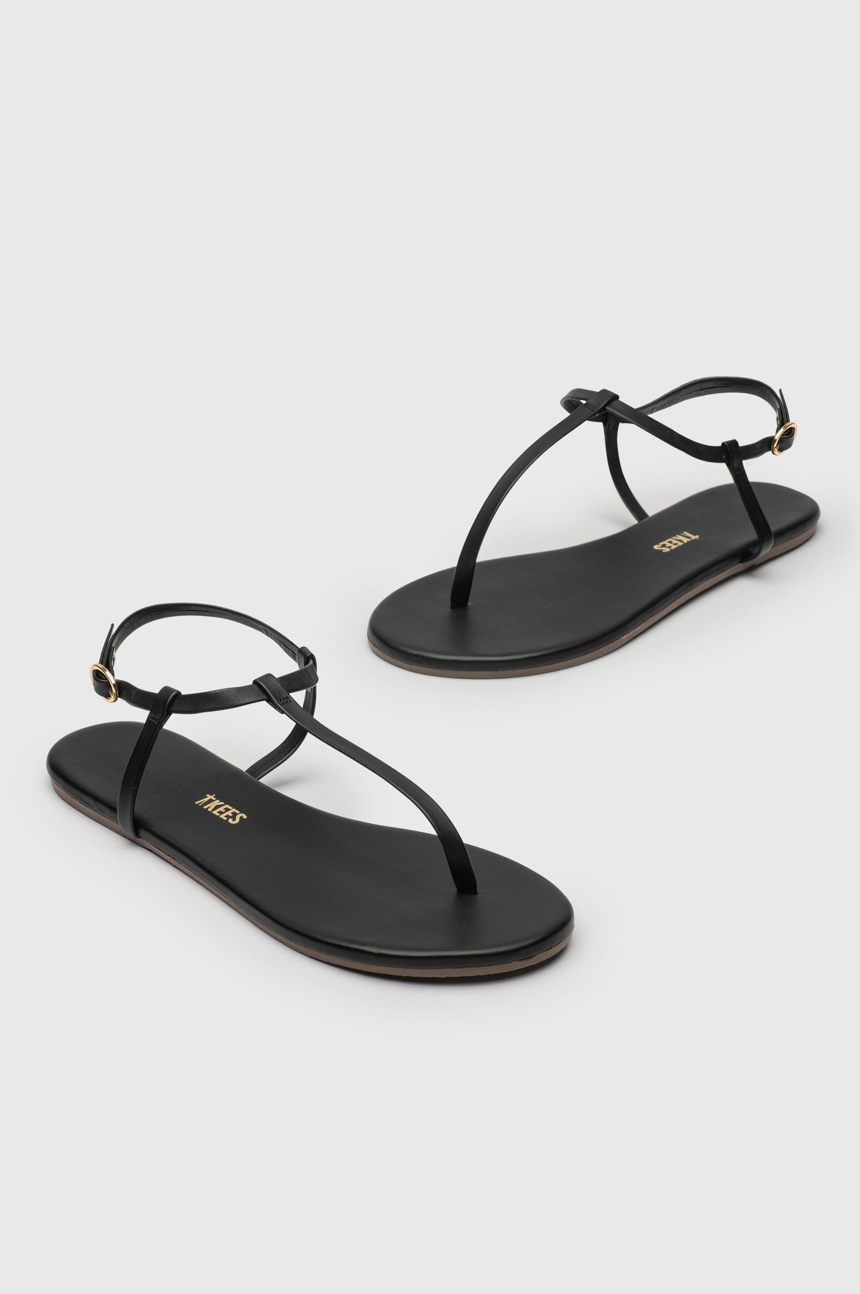 Mariana leather t-strap sandal with ankle strap and buckle in Sable black - cross angled view of pair of shoes