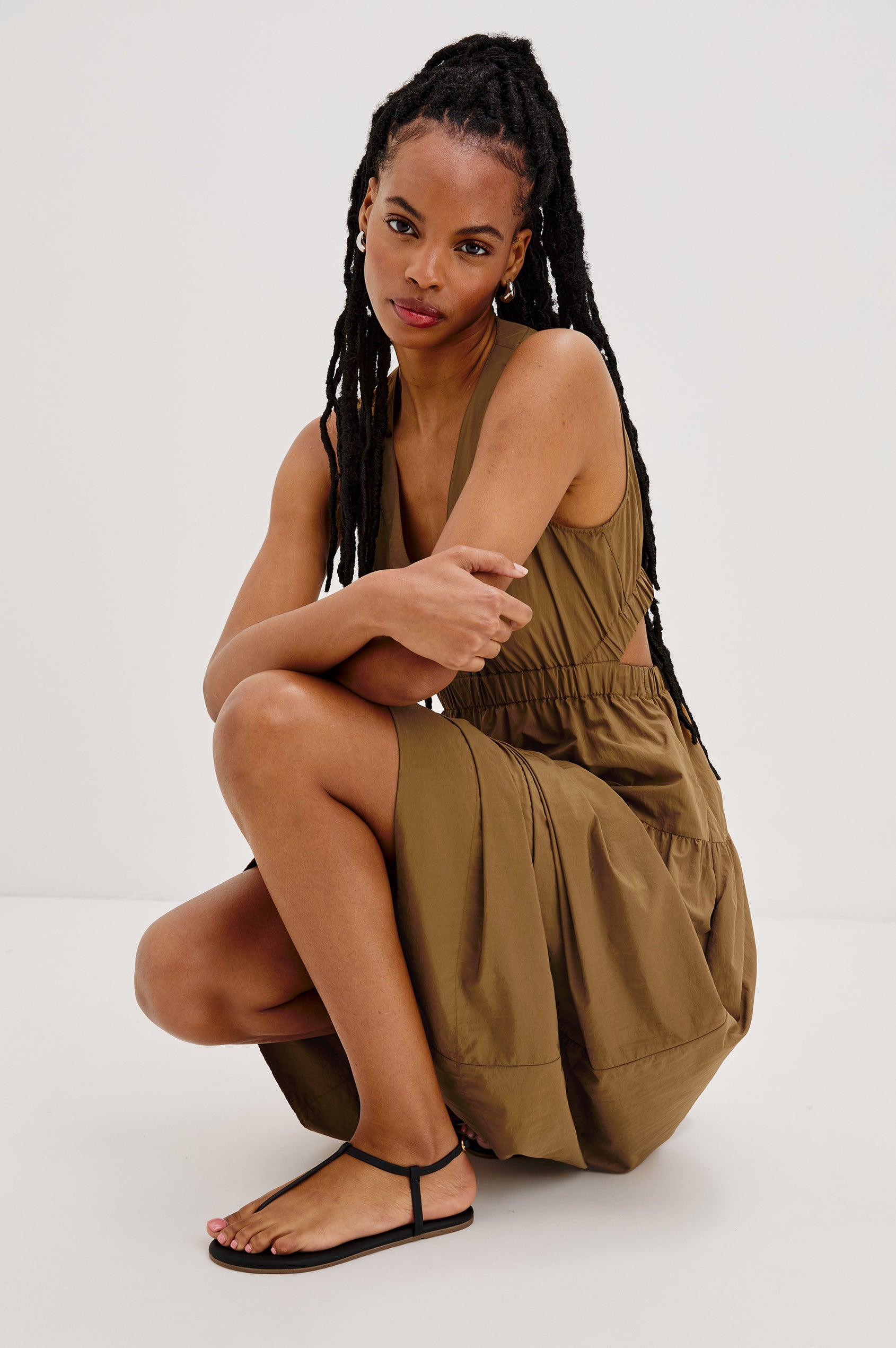 Mariana leather t-strap sandal with ankle strap and buckle in Sable black - front view with model squatting down