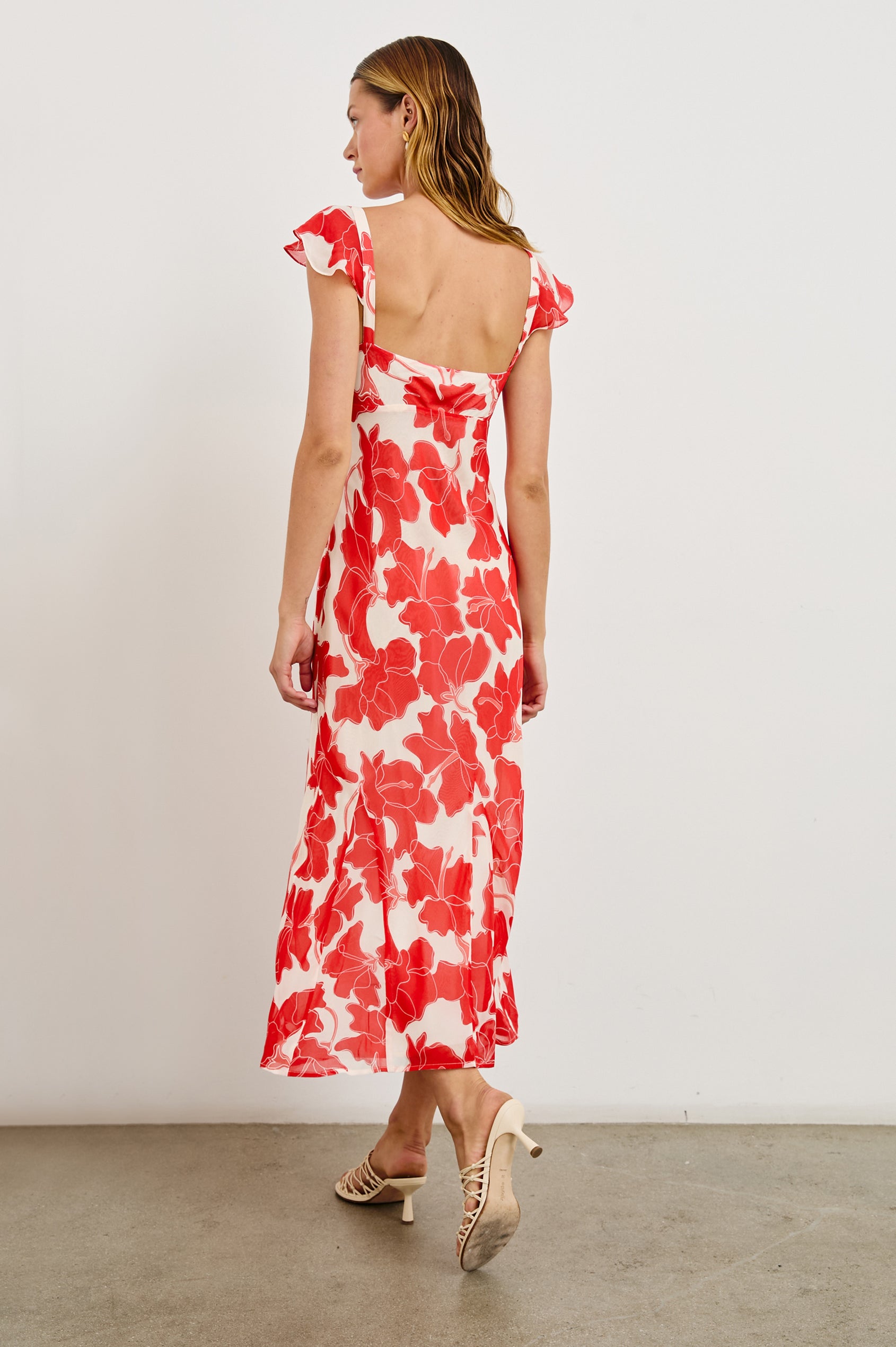 Marigold Midi Dress with Cap Ruffled Sleeves and a Scoop Neckline in Scarlet Hibiscus Colorway on white - Back Full Body View Featured on Model