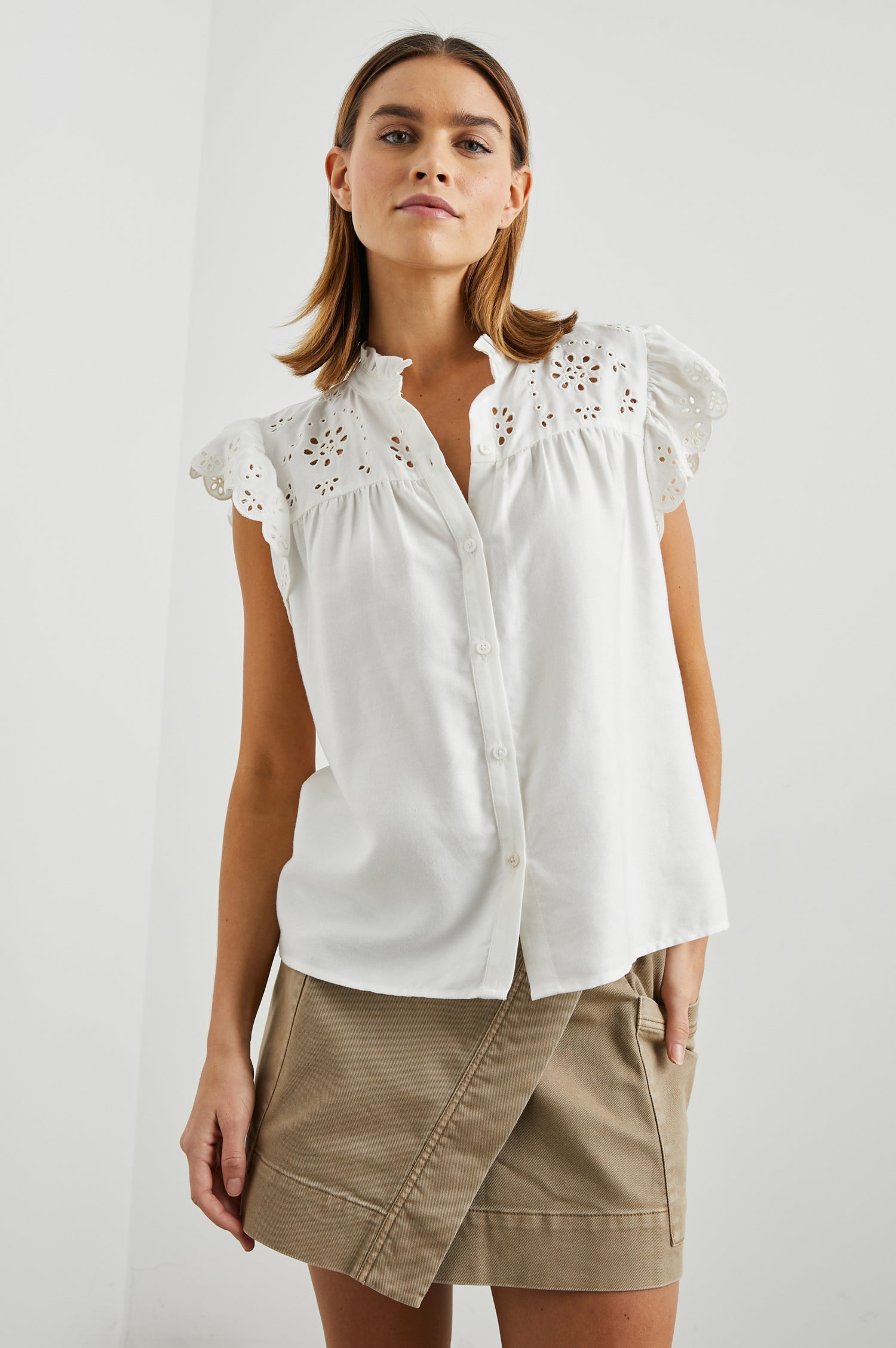 Marlene Short-Sleeve Button Up with Flutter Sleeves, Floral Eyelets on the Yoke and Sleeves, and Light Ruching along the Yoke Seams in White Denim Colorway - Front View Featured on Model 