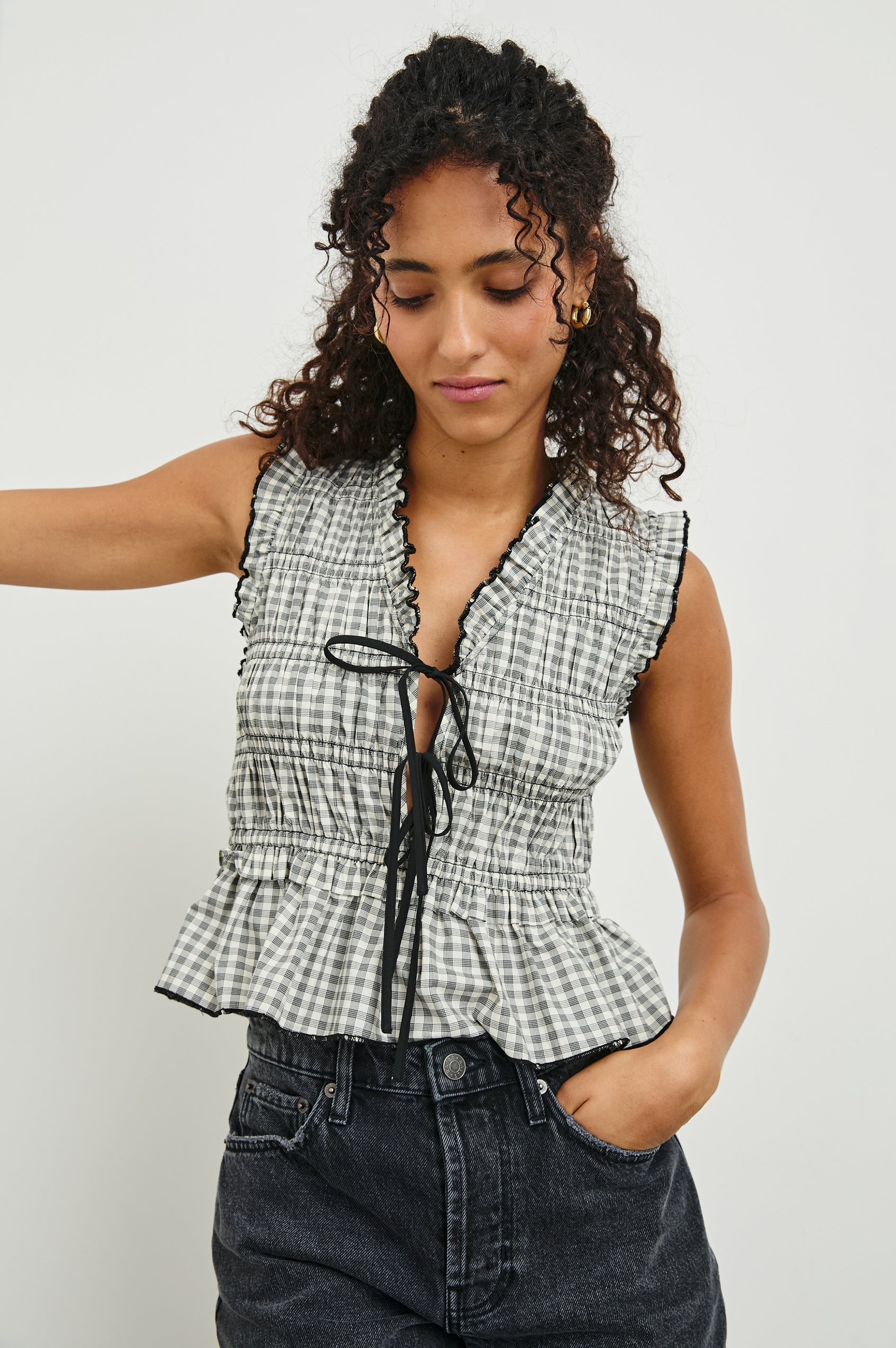 Martine Sleeveless Top with Ruffled Trim, a Deep V-Neck with Ties and Smocking in Ivory Jet Gingham Colorway - Front View Featured on Model 