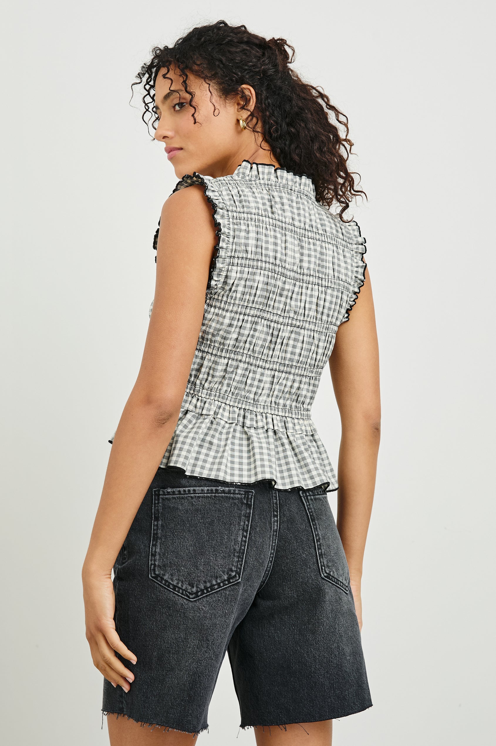 Martine Sleeveless Top with Ruffled Trim, a Deep V-Neck with Ties and Smocking in Ivory Jet Gingham Colorway - Back View Featured on Model 
