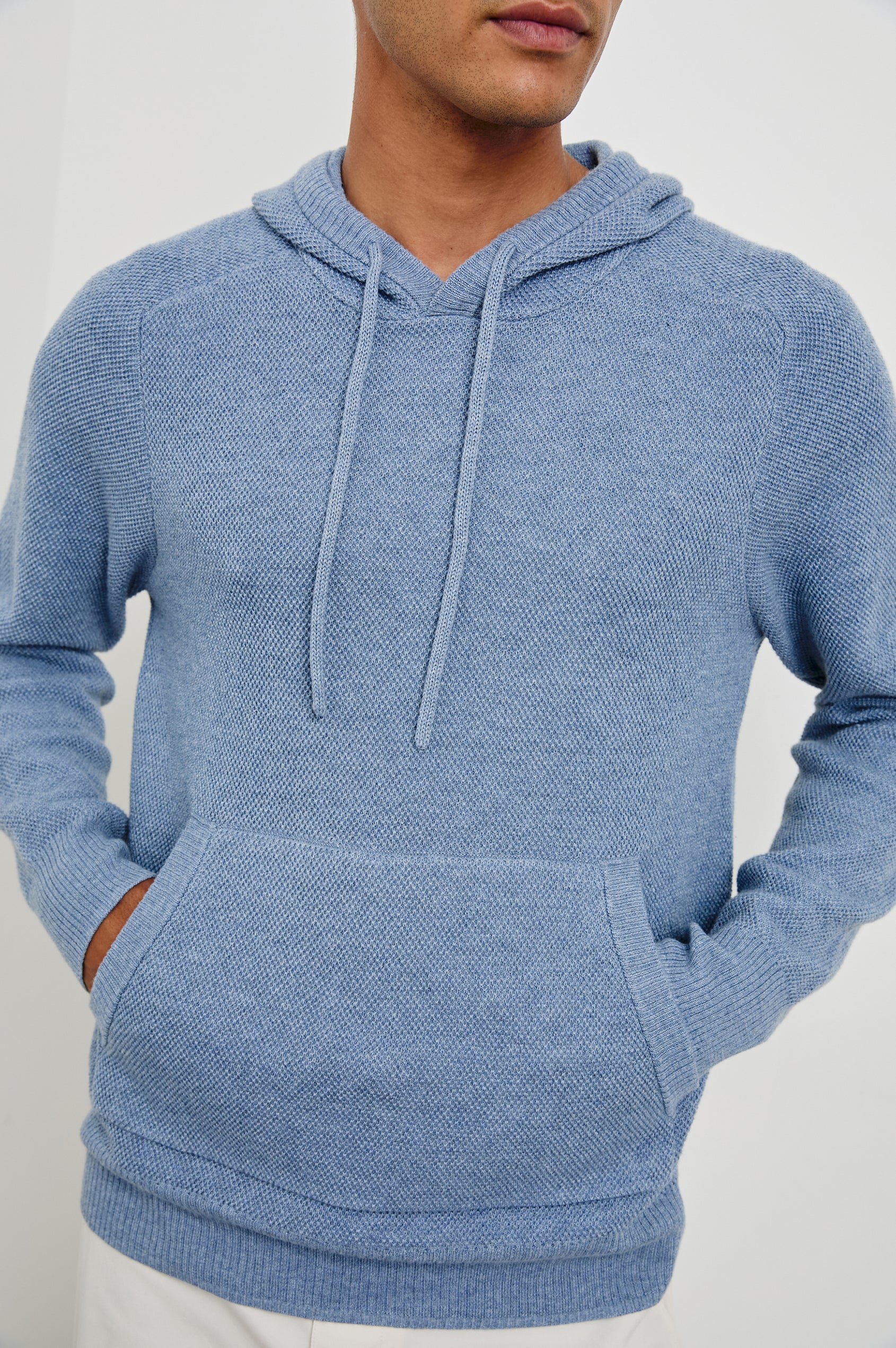Matador knit sweater with hoodie, adjustable drawstrings, and dual side front pocket in Light Blue Heather - close up of details on model
