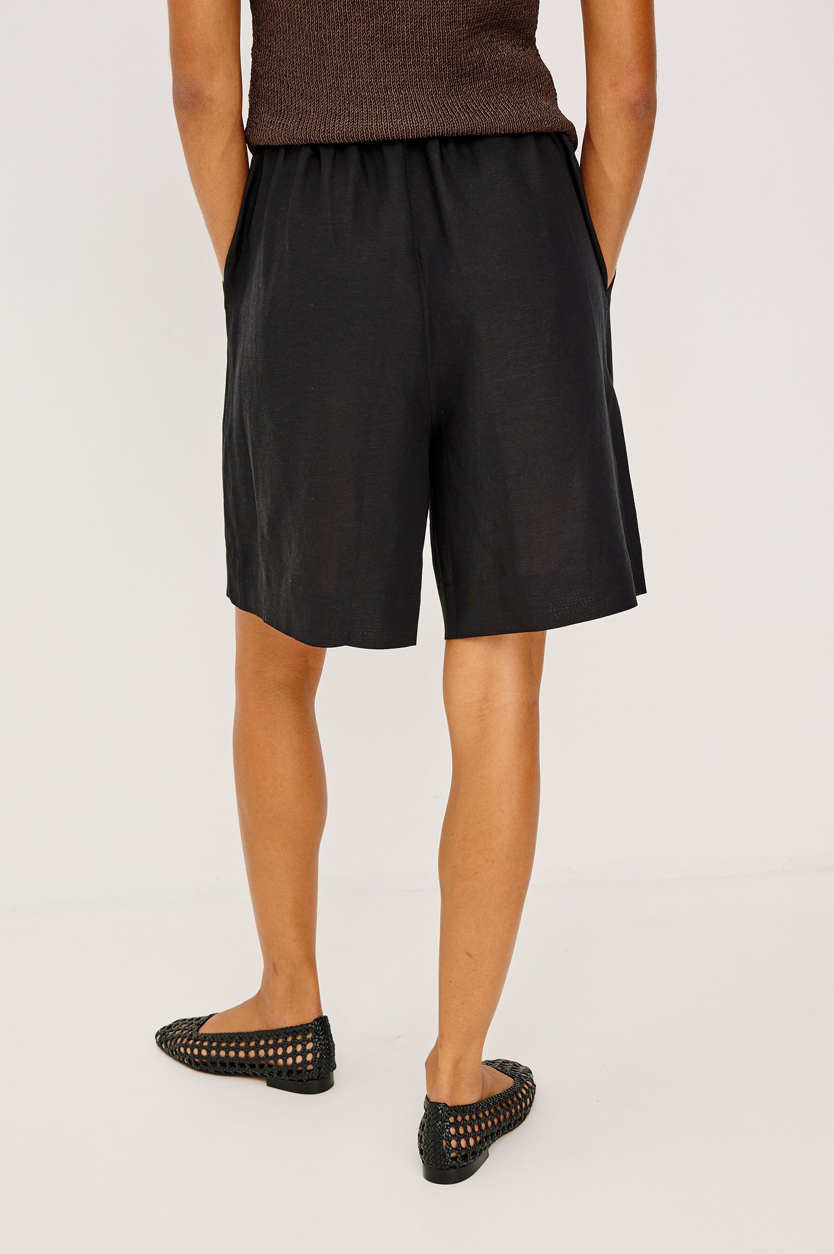 McGuire Mid-Rise Short in Linen Viscose With Bermuda Length, Elastic Waist With Drawcords, Pockets, and Loose Relaxed Fit in Black Colorway - Lower Body Back View Featured on Model