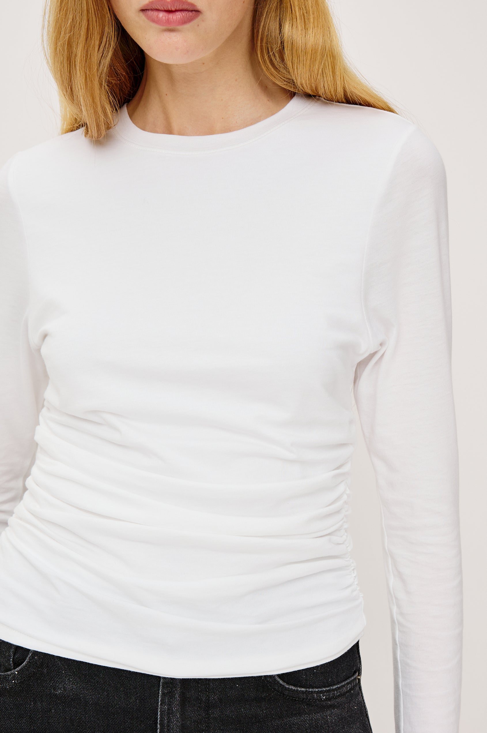 Melle Fitted Top in Organic Cotton With Crew Neckline, Side Shirring, and Long Sleeves in White Colorway - Upper Body Close Up Front View Featured on Model